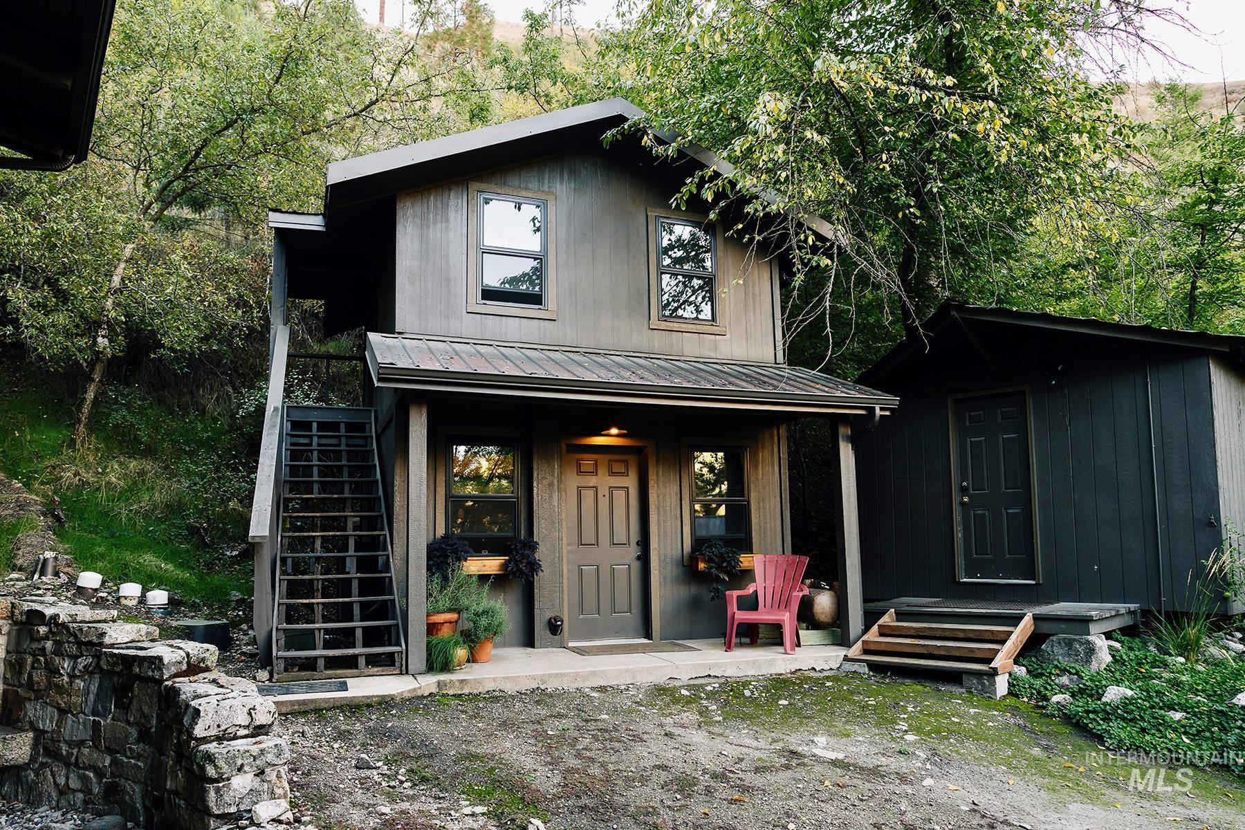View of front of home with a metal roof, stairs, and a porch