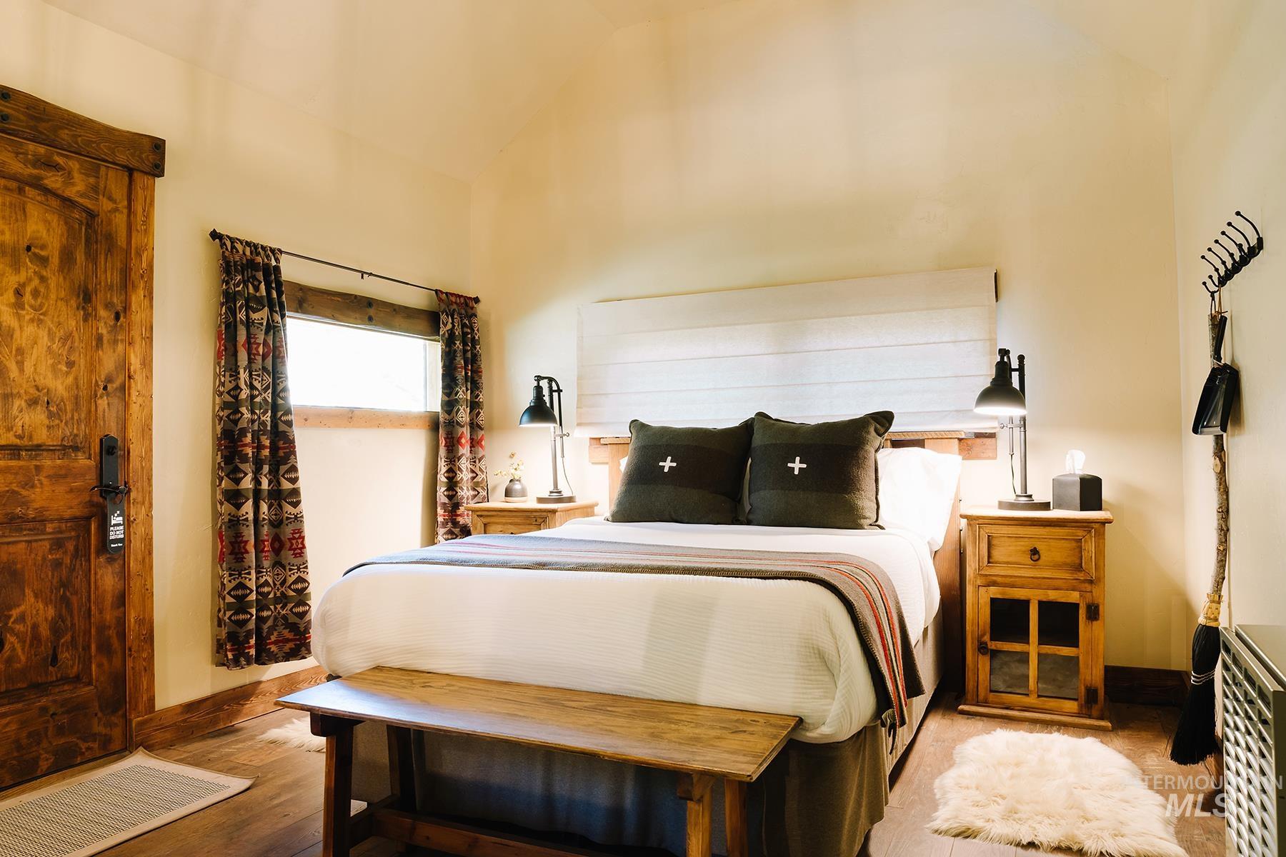 Bedroom featuring lofted ceiling and wood finished floors