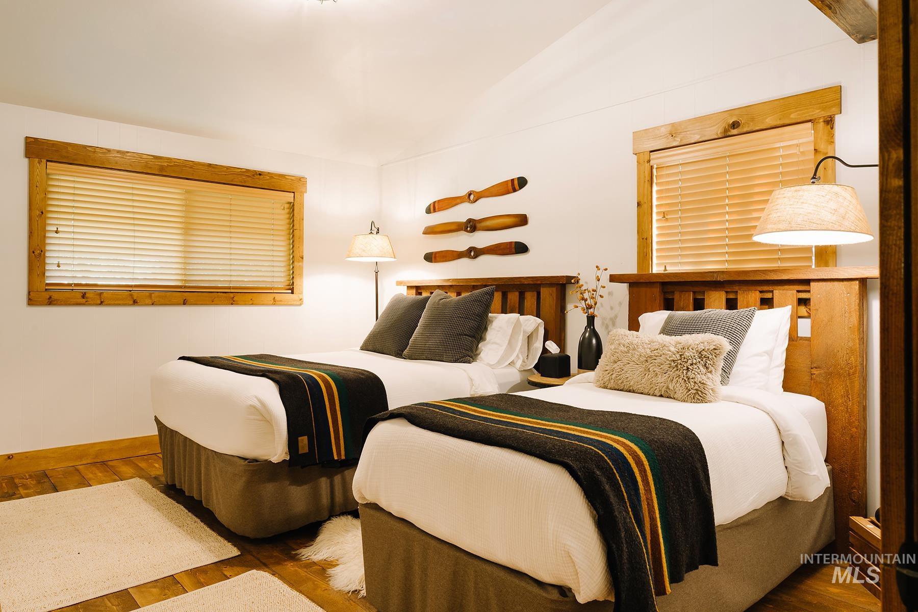 Bedroom with wood-type flooring and vaulted ceiling