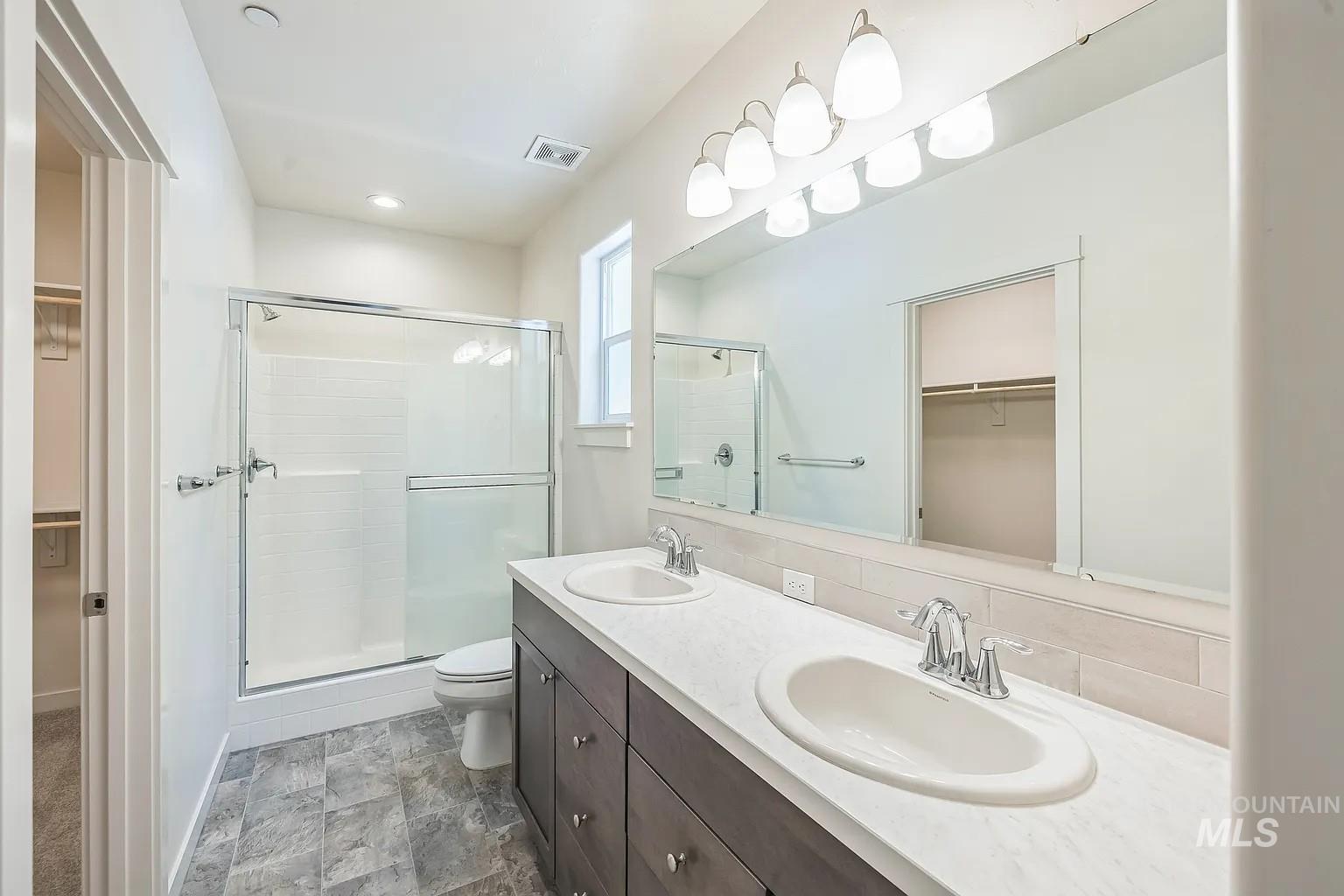 Contemporary bathroom featuring a double vanity with dark wood cabinetry, white countertops, and dual undermount sinks
