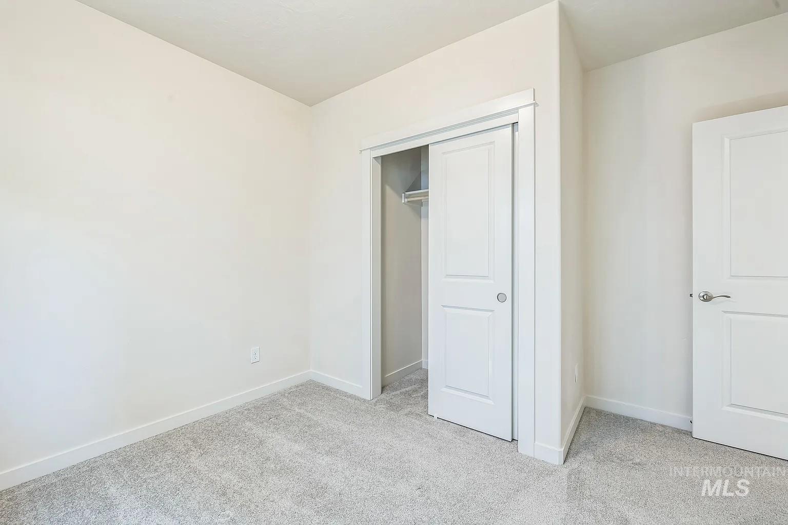 Bedroom featuring light-colored walls and grey carpet flooring
