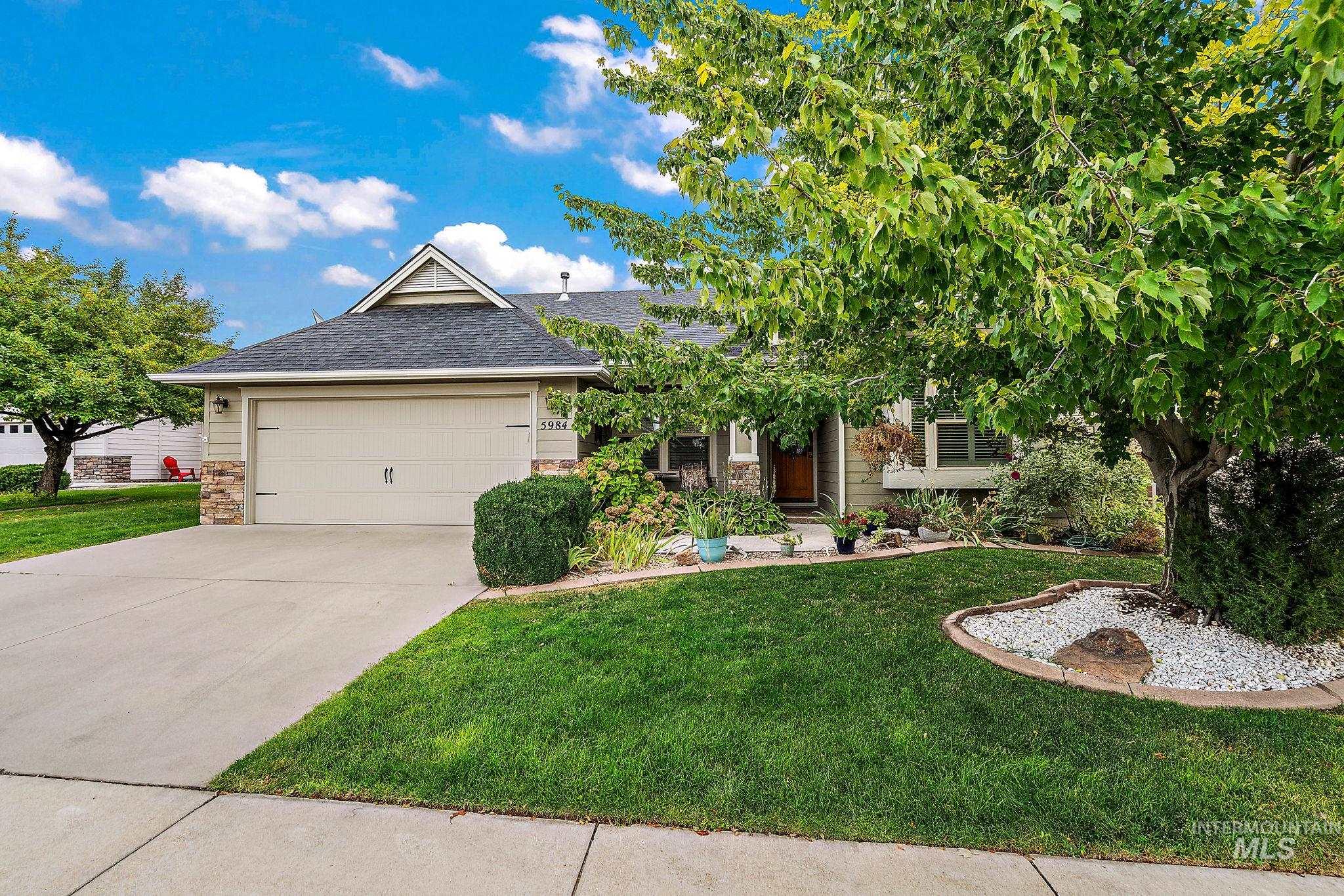 View of front facade with a front lawn, a shingled roof, concrete driveway, and an attached garage