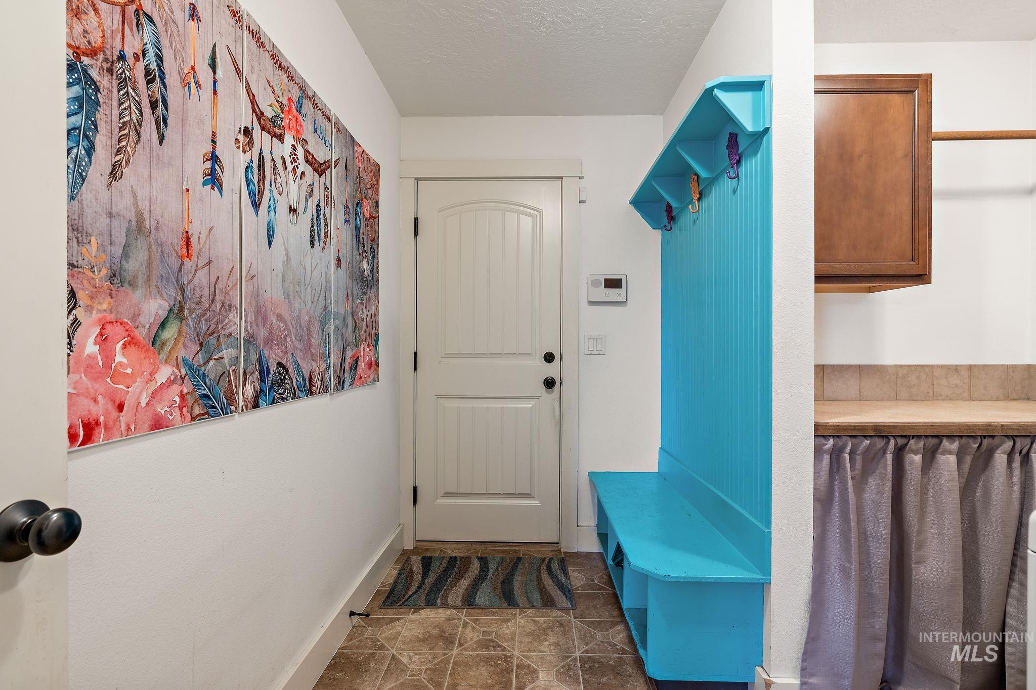 Mudroom featuring a textured ceiling and dark tile patterned floors