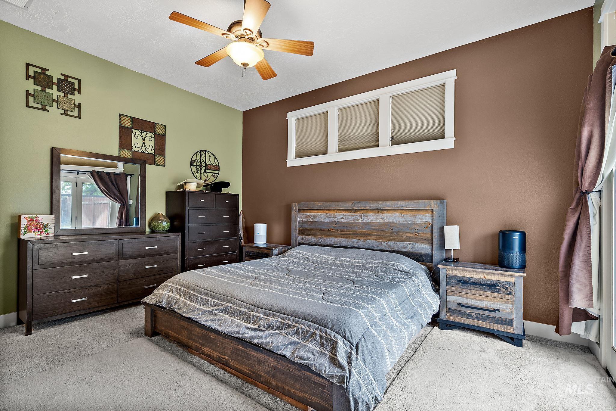 Carpeted bedroom with ceiling fan and baseboards