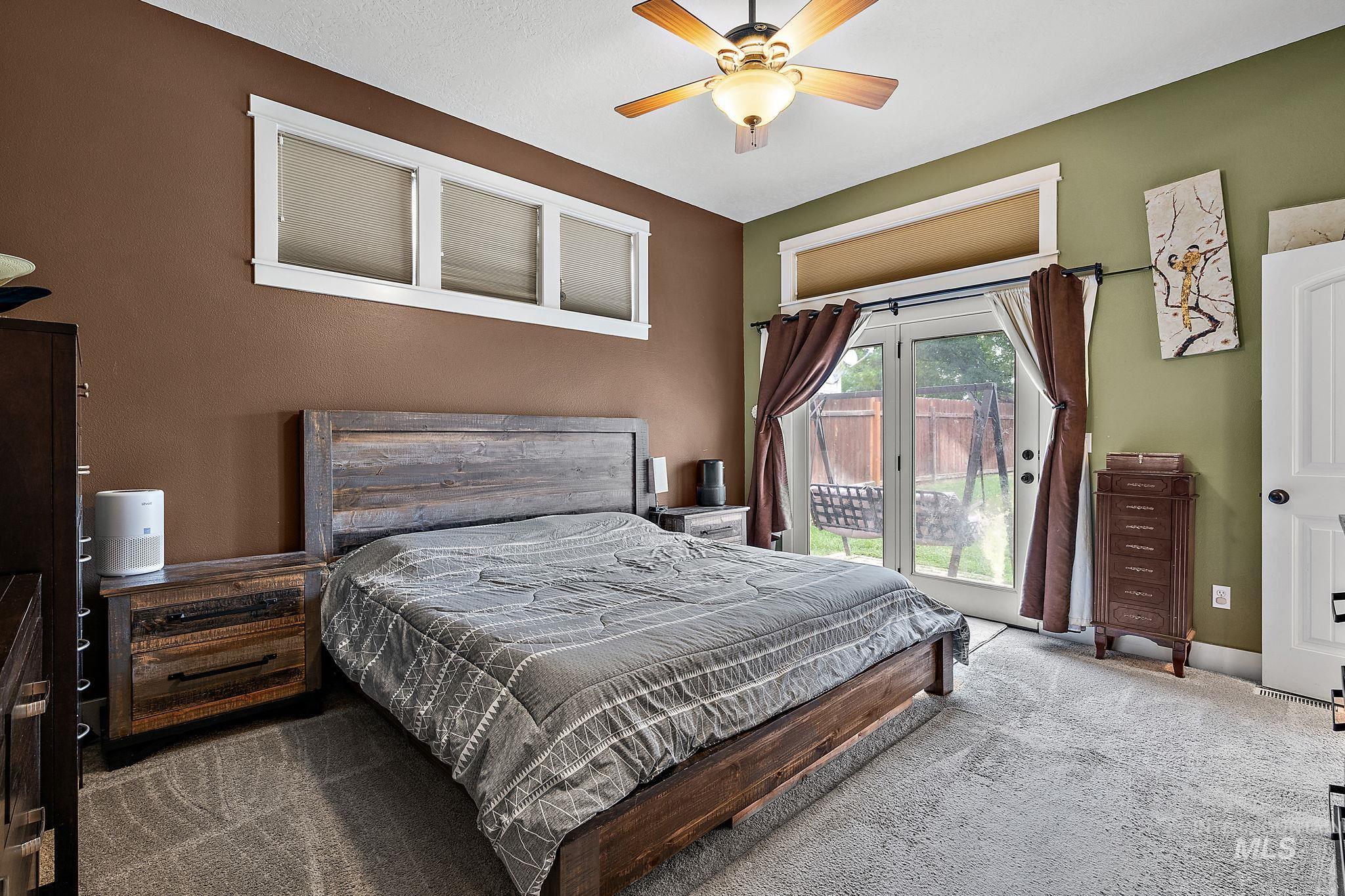 Carpeted bedroom with access to exterior and a ceiling fan
