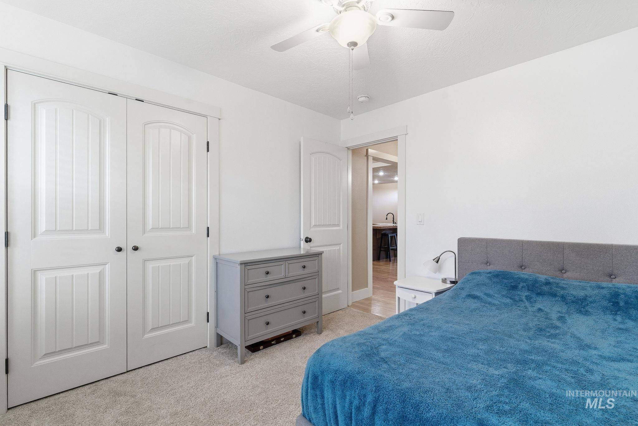 Bedroom featuring light carpet, a closet, and ceiling fan