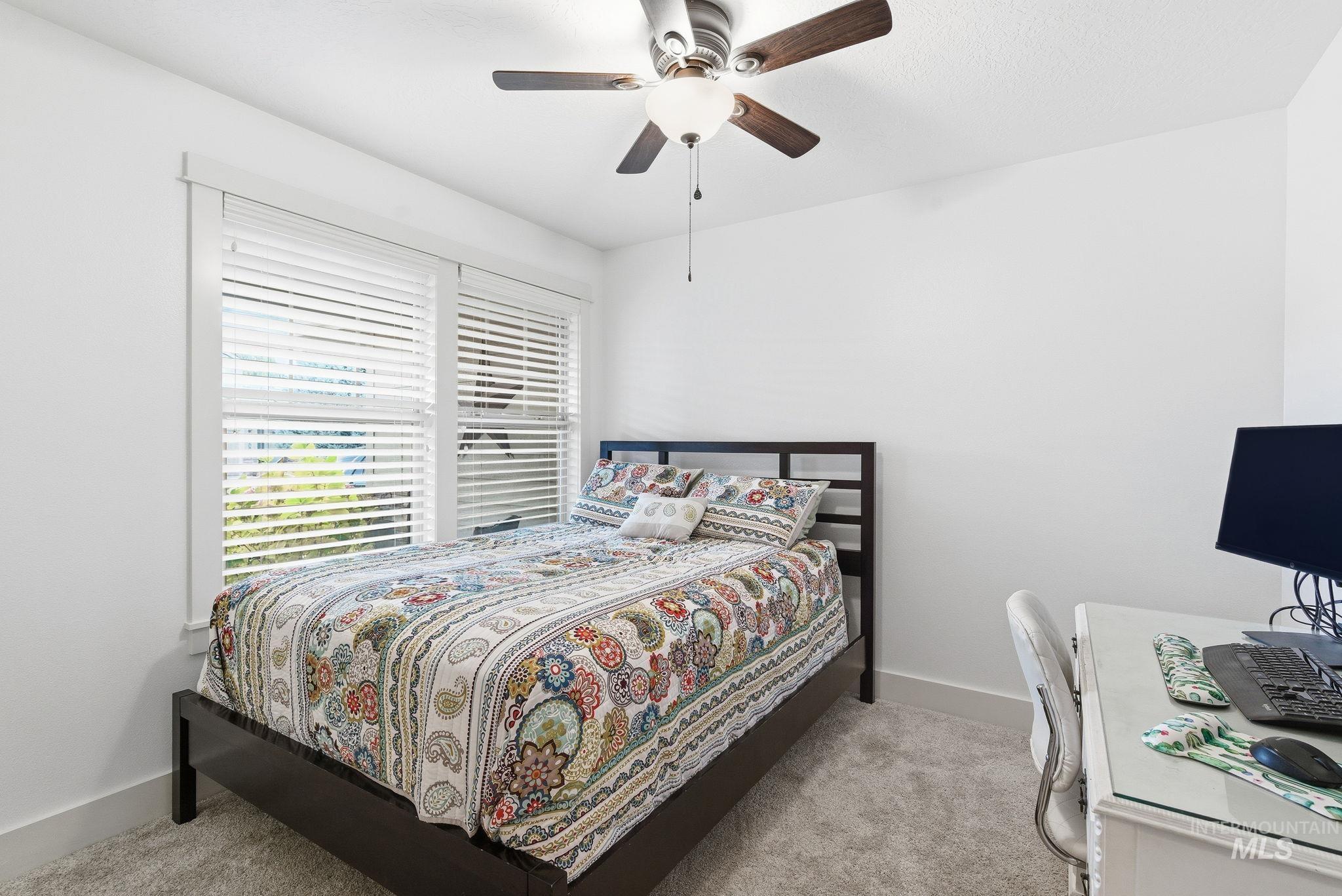 Bedroom with light colored carpet and ceiling fan