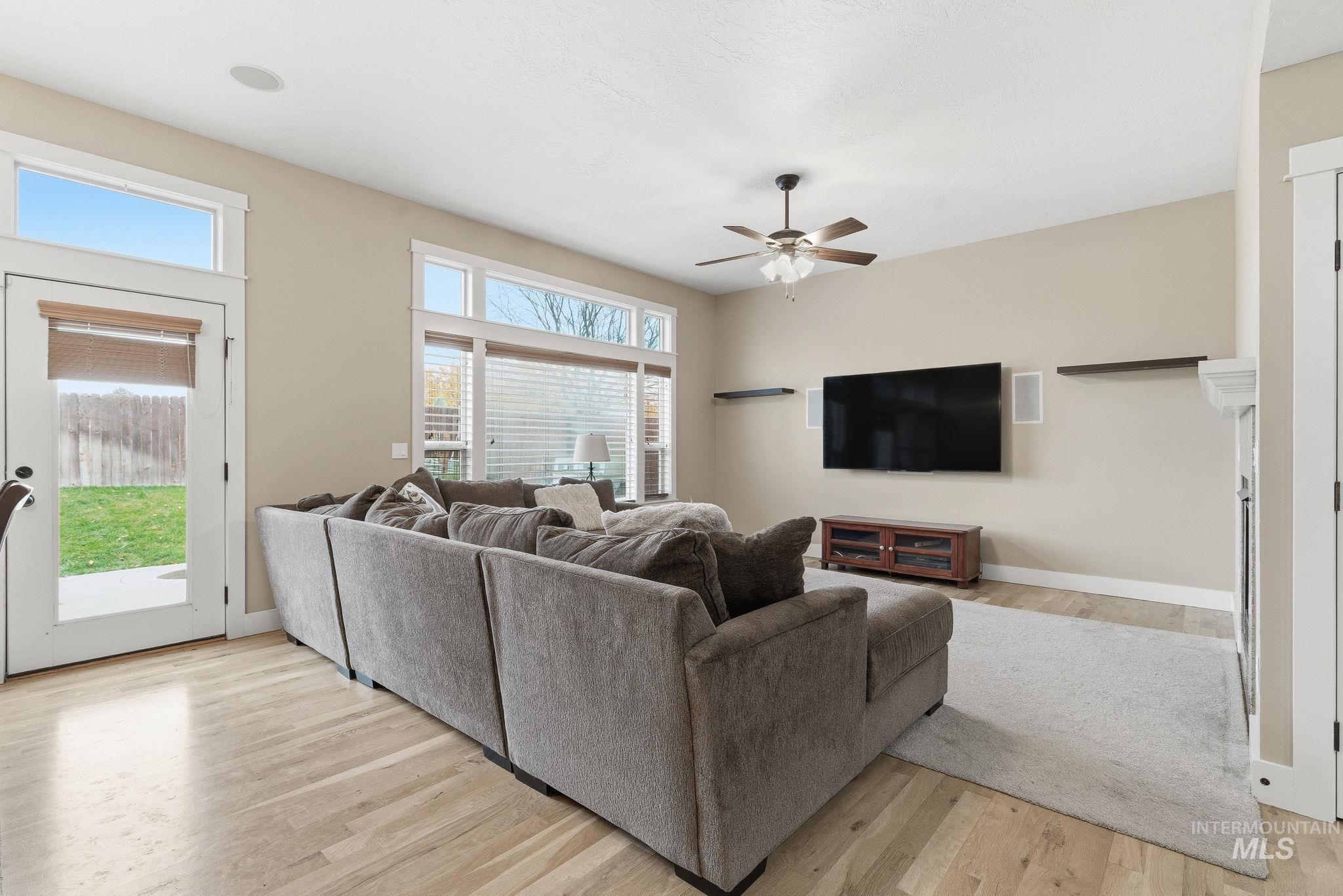 Living room with light wood-style floors and ceiling fan