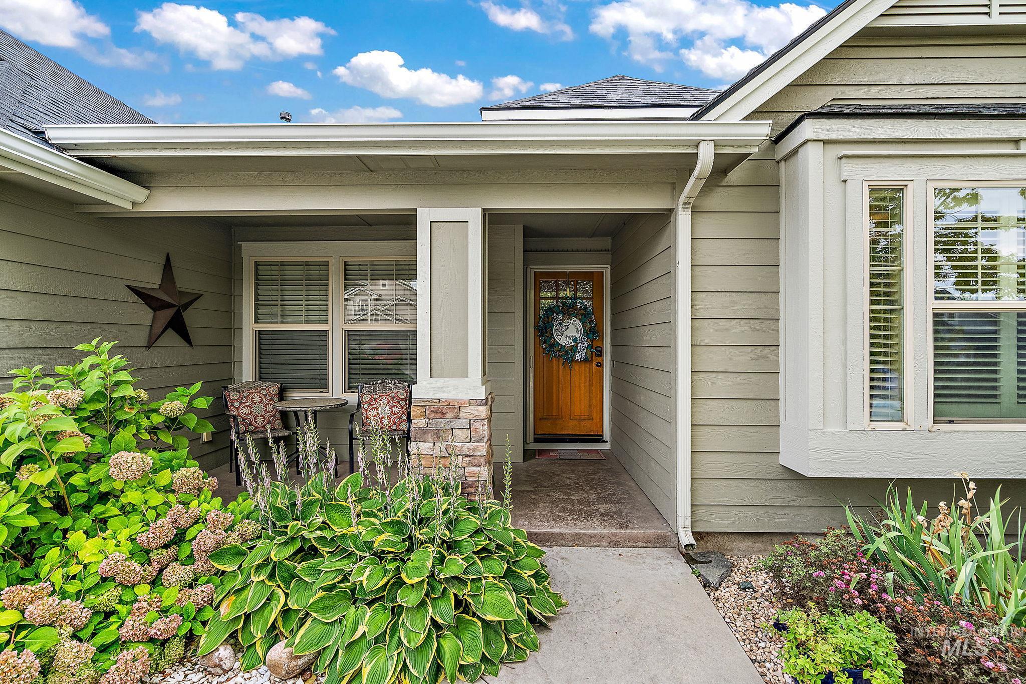View of exterior entry featuring roof with shingles and a porch