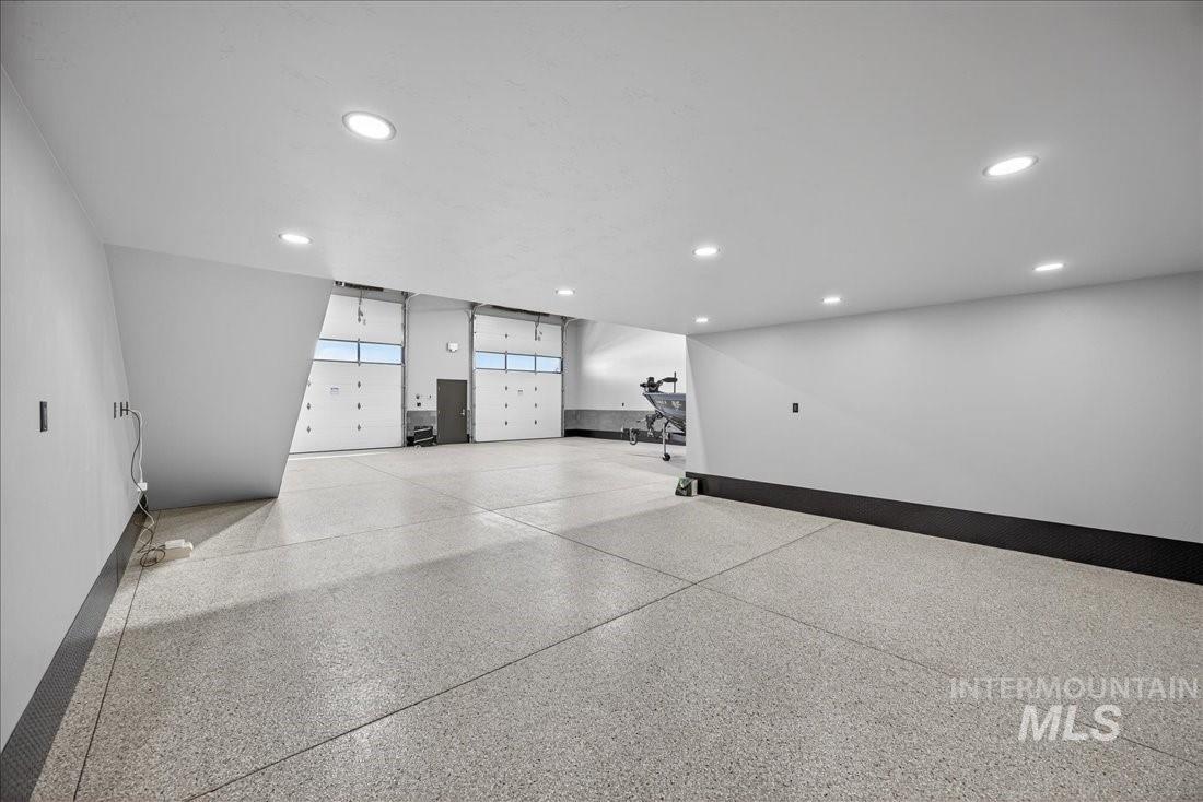 Interior space featuring dark aggregate flooring and recessed lighting