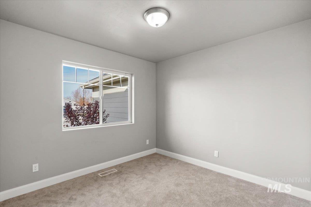 Carpeted empty room featuring baseboards