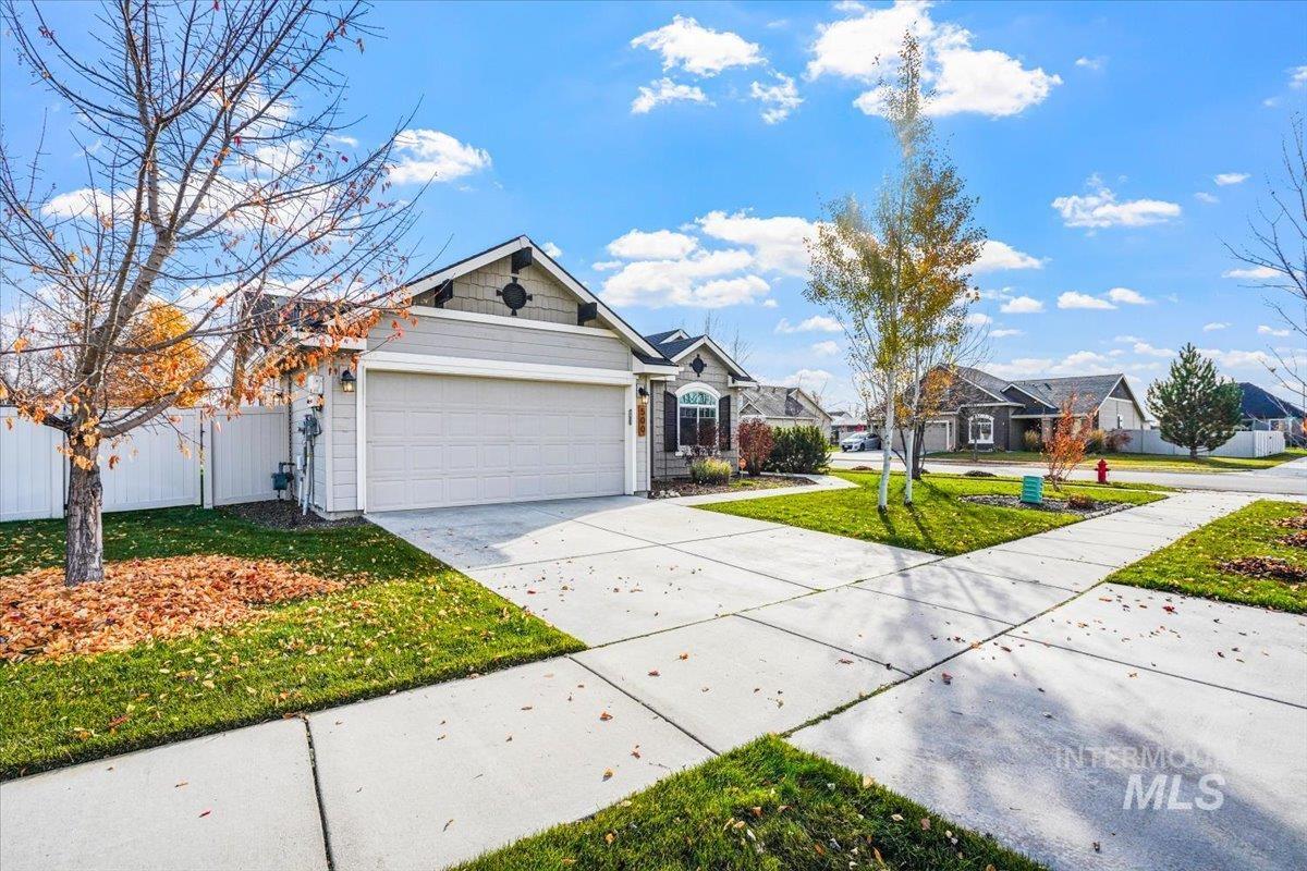 View of front of home with driveway, an attached garage, and a residential view