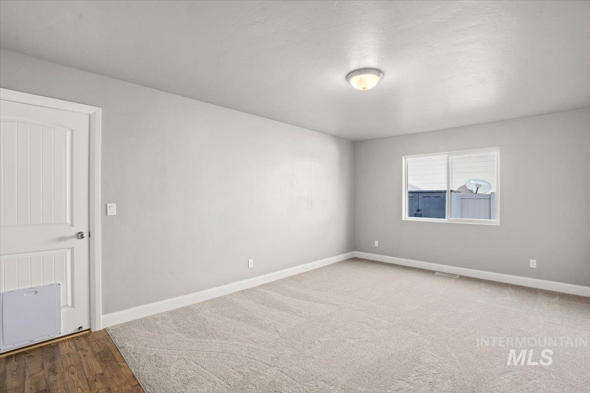 Carpeted empty room with baseboards