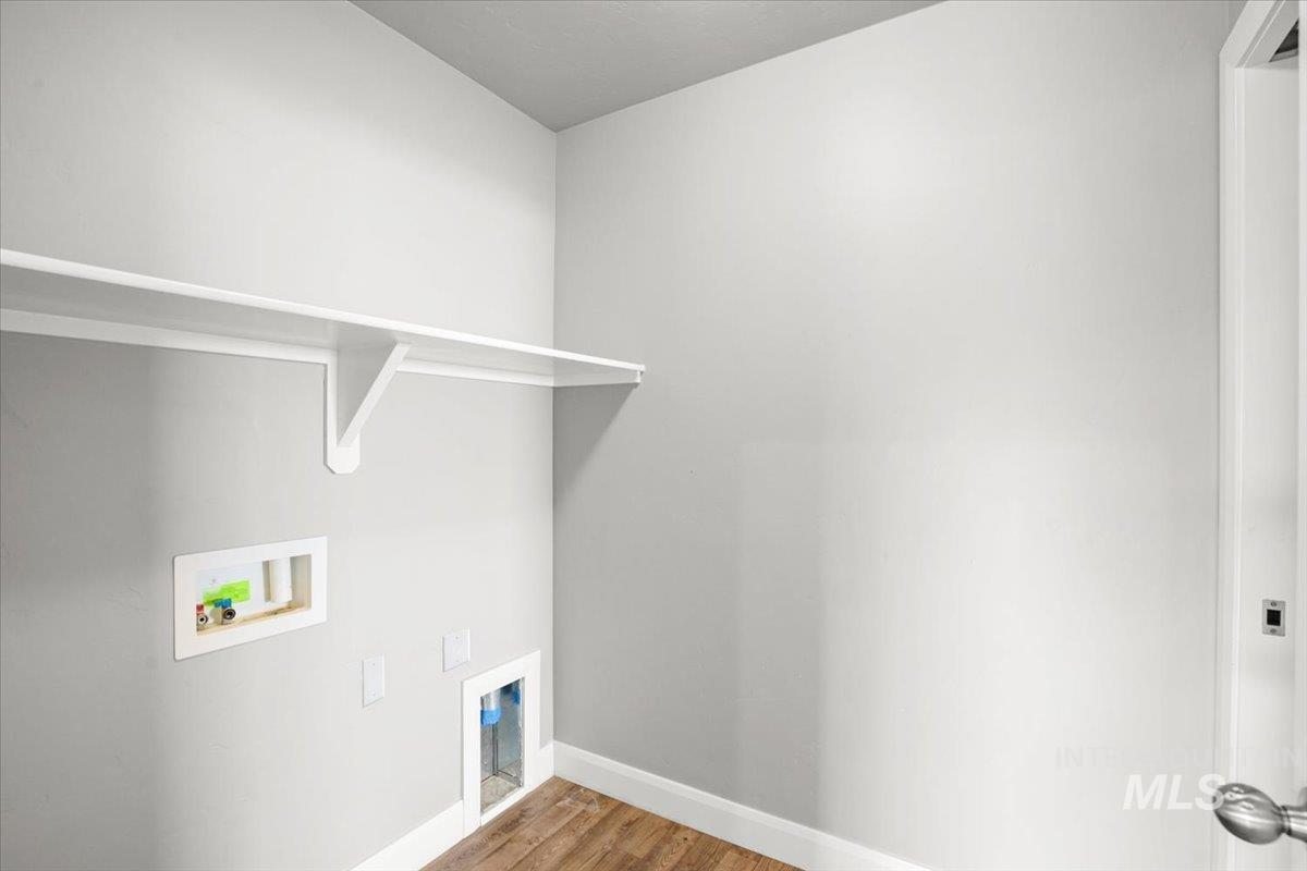 Laundry area with hookup for a washing machine and wood finished floors