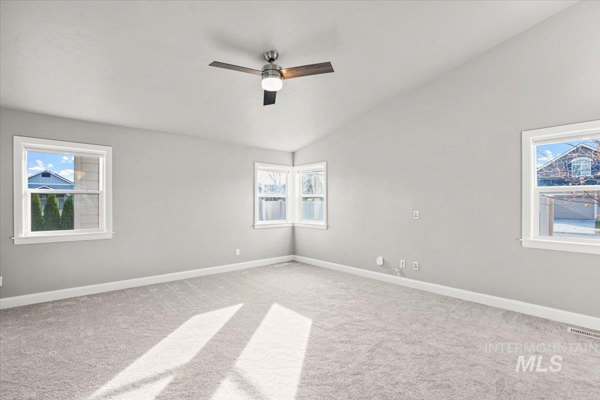Unfurnished room with lofted ceiling, carpet flooring, and ceiling fan