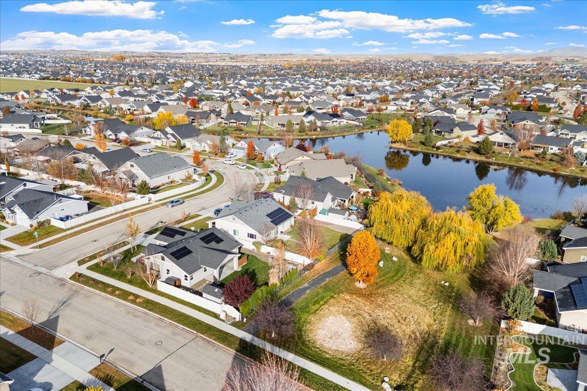 Aerial view of property and surrounding area featuring nearby suburban area and a nearby body of water
