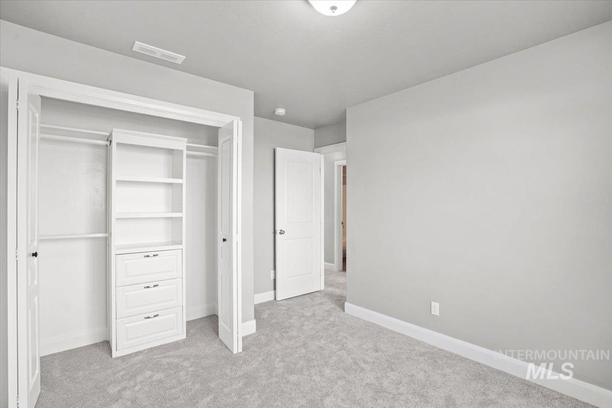 Unfurnished bedroom with light colored carpet and a closet