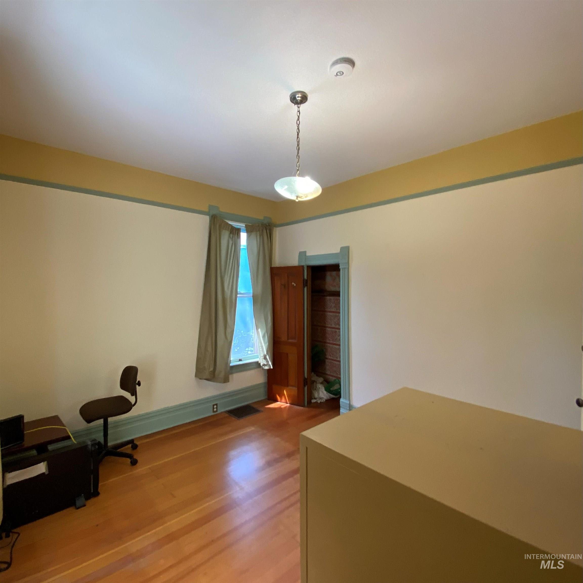 Unfurnished office featuring light wood finished floors and baseboards