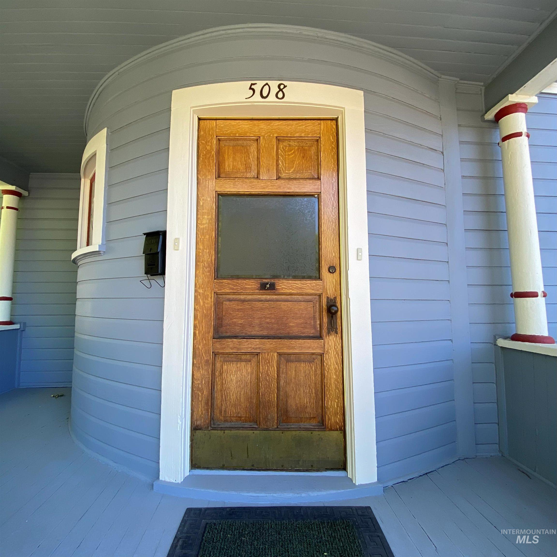 Doorway to property featuring covered porch