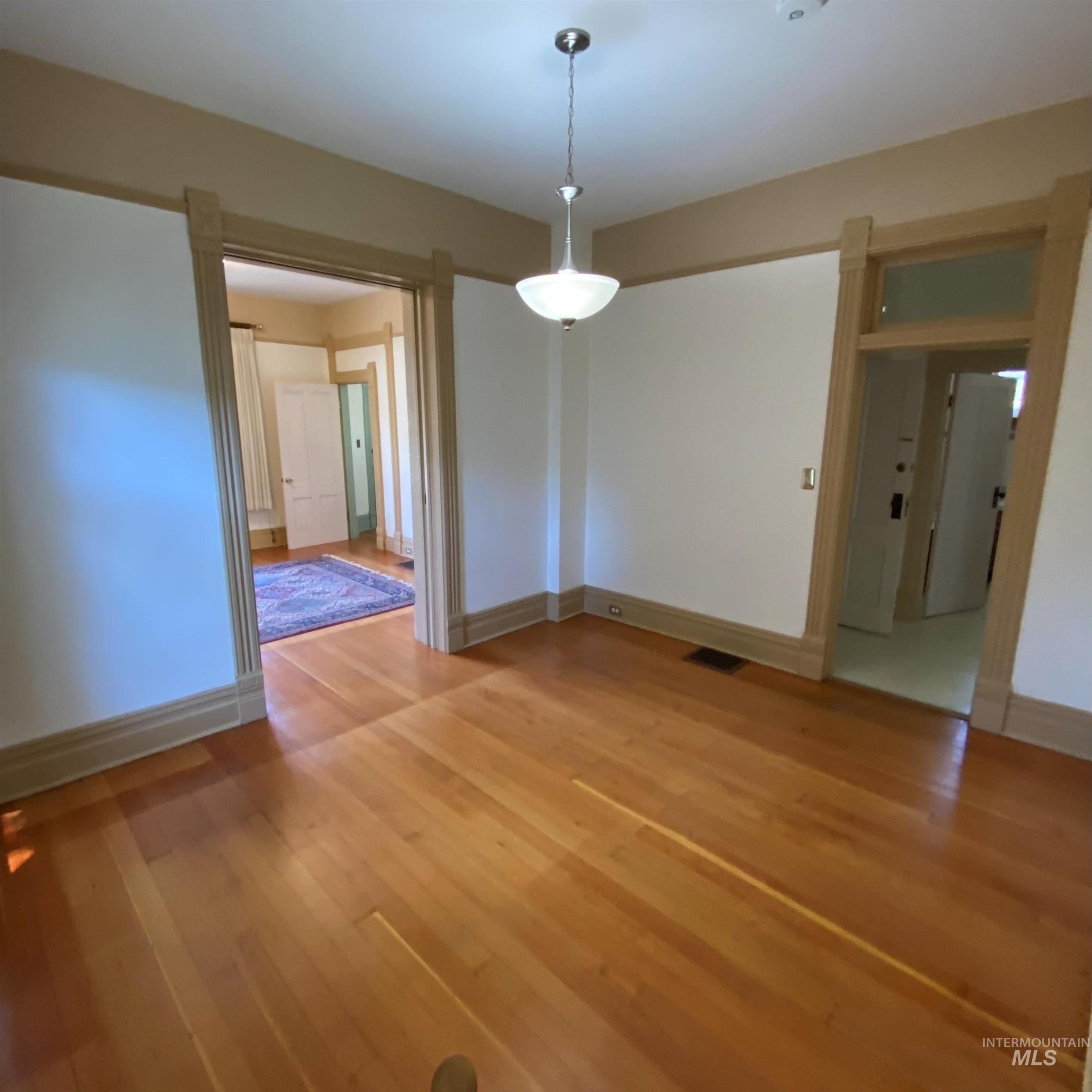 Unfurnished dining area featuring light wood-style floors and baseboards