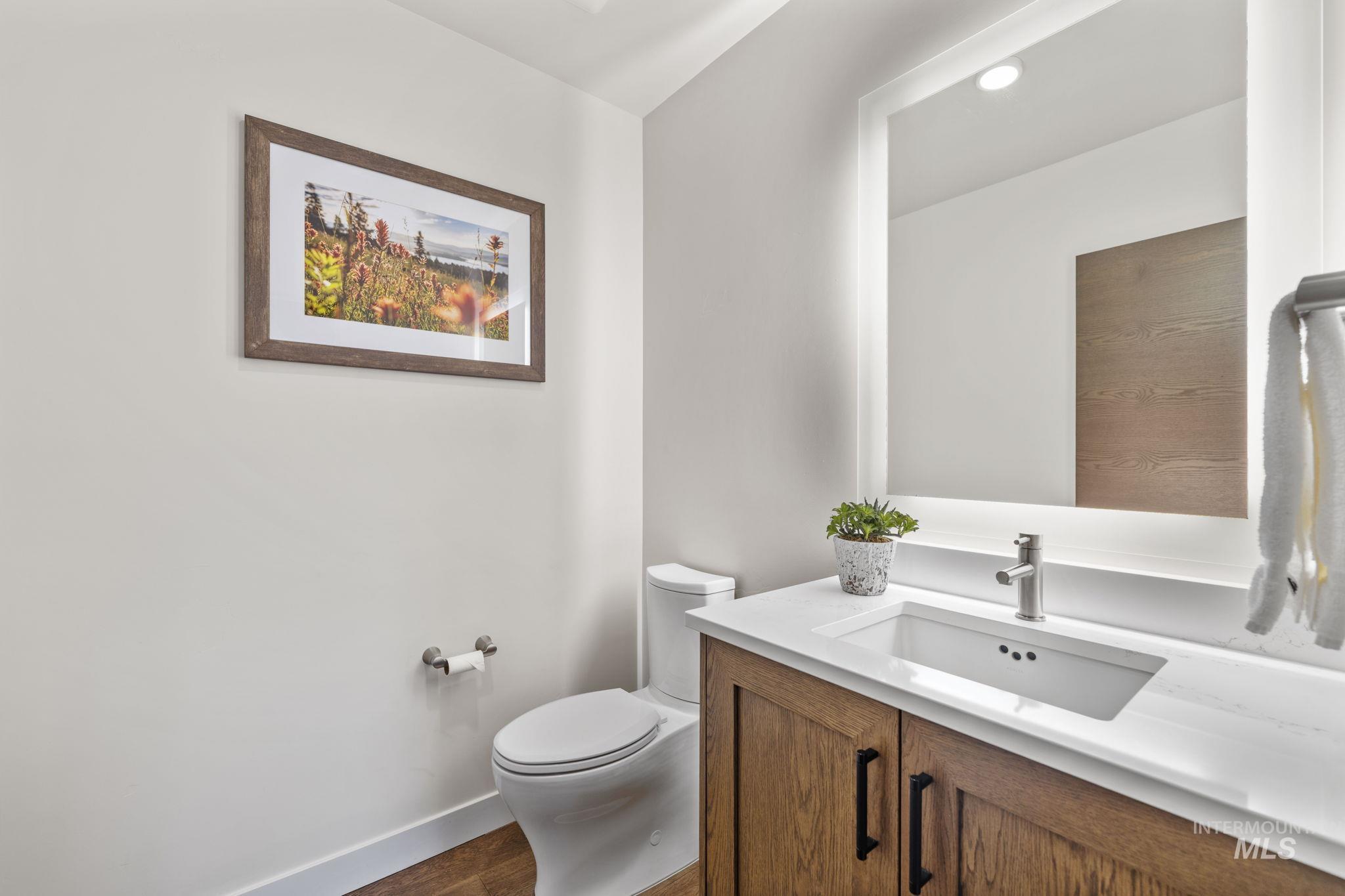 Bathroom with vanity, recessed lighting, and dark wood finished floors
