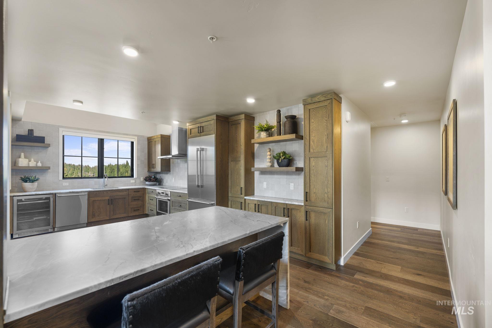 Kitchen with open shelves, tasteful backsplash, appliances with stainless steel finishes, dark wood finished floors, and recessed lighting