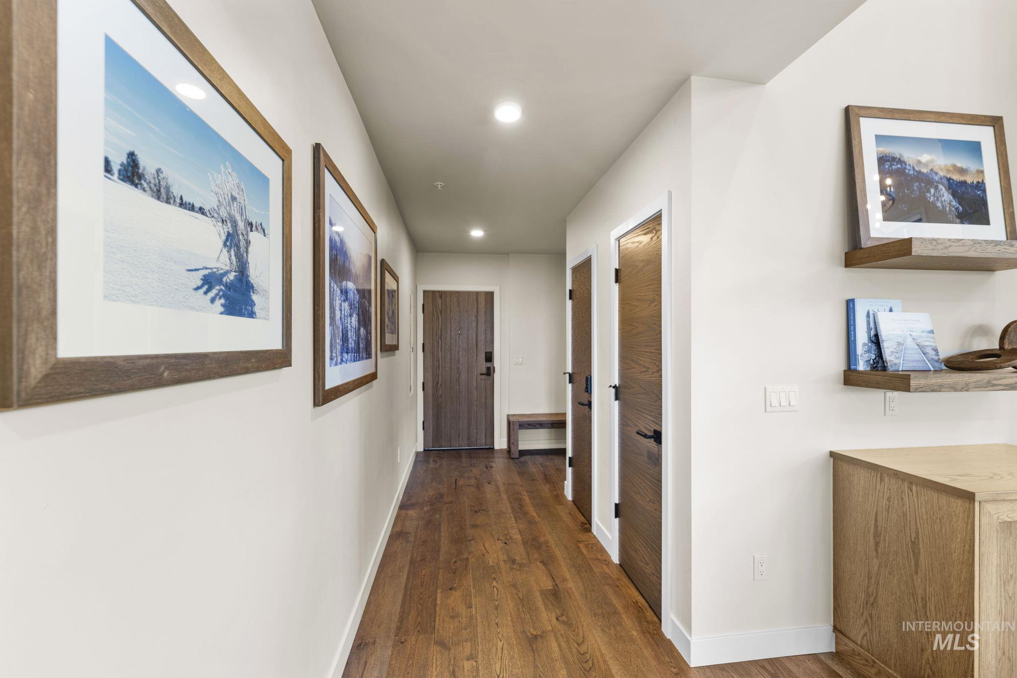Hall featuring dark wood-type flooring and recessed lighting