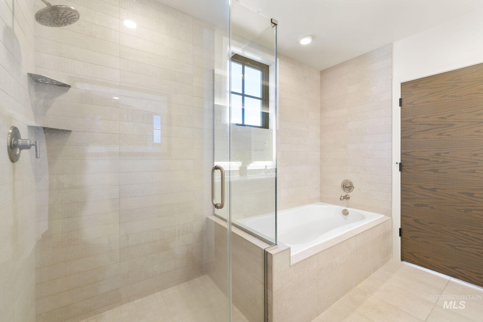 Full bath featuring a garden tub, a shower stall, and tile patterned flooring