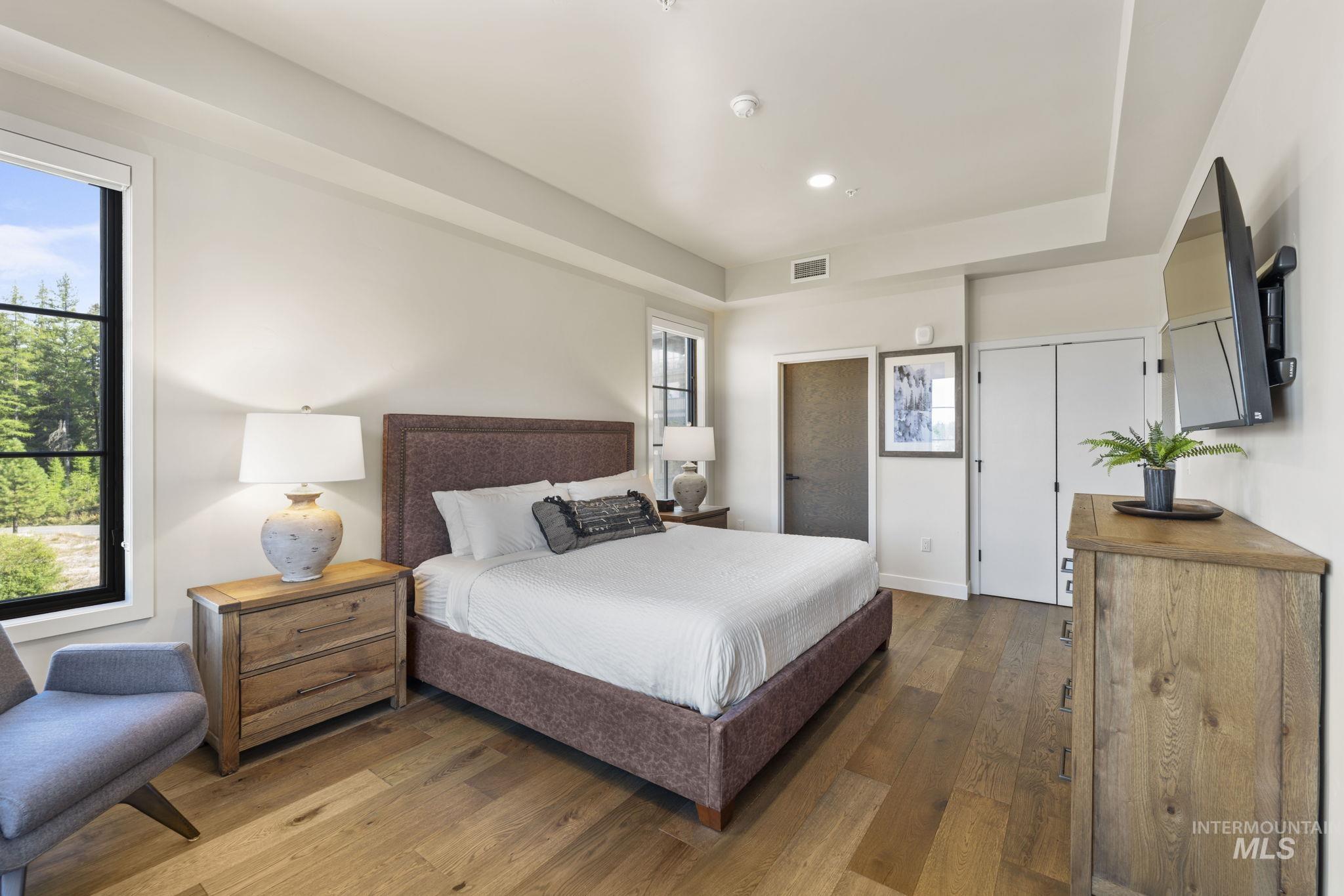 Bedroom with dark wood-style floors and recessed lighting