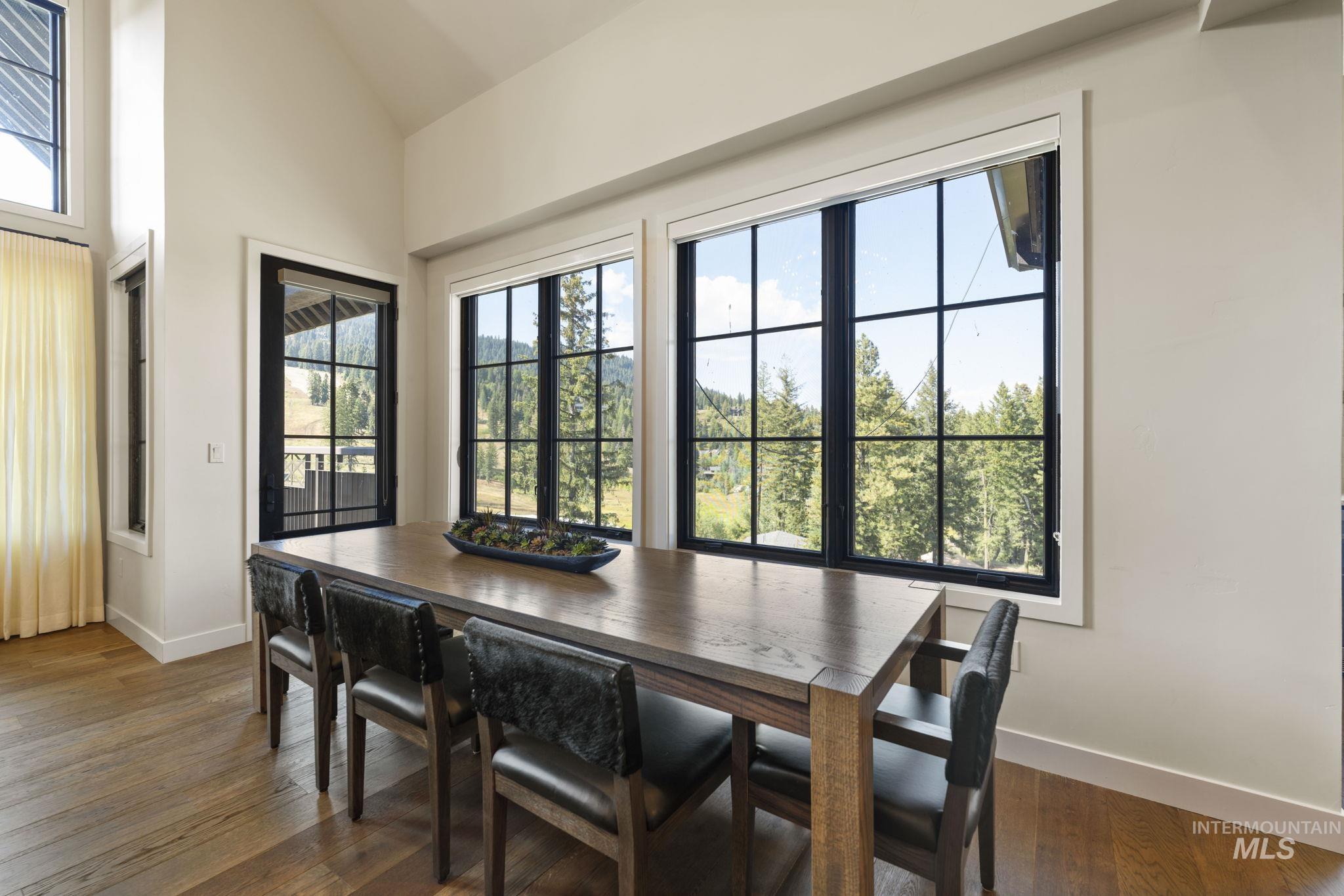 Dining space featuring dark wood finished floors and high vaulted ceiling