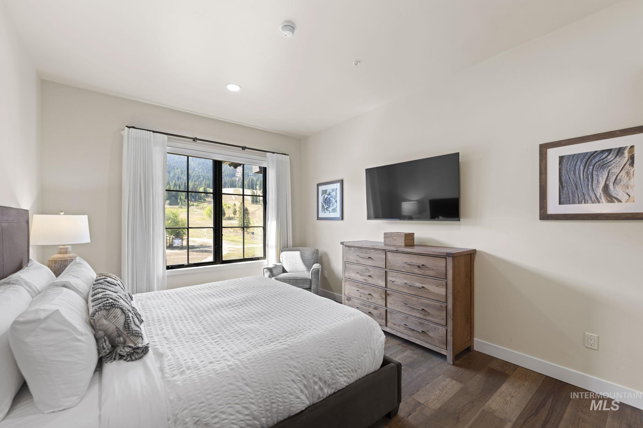 Bedroom with dark wood finished floors and recessed lighting