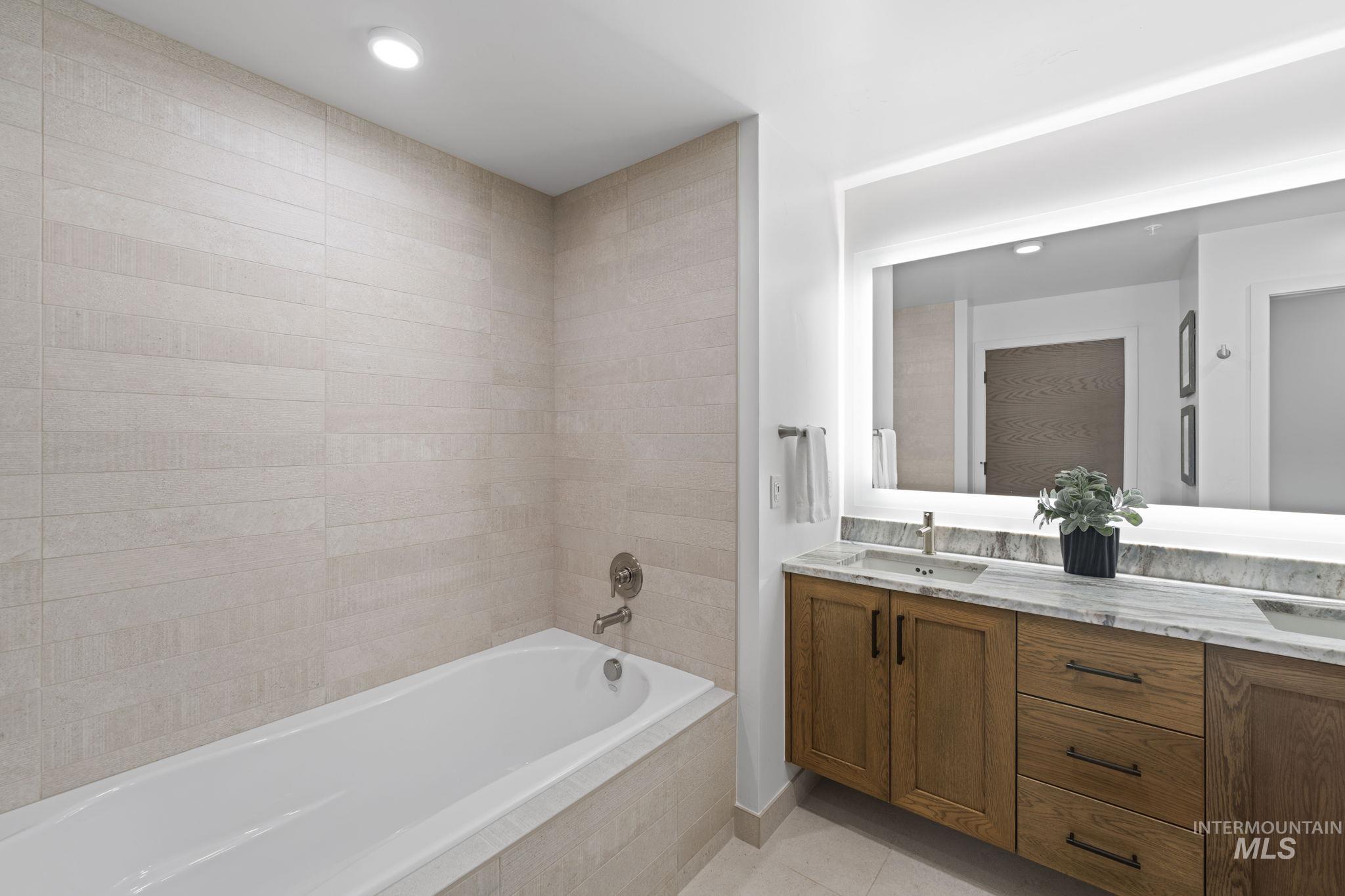 Full bathroom with double vanity, light tile patterned floors, and recessed lighting