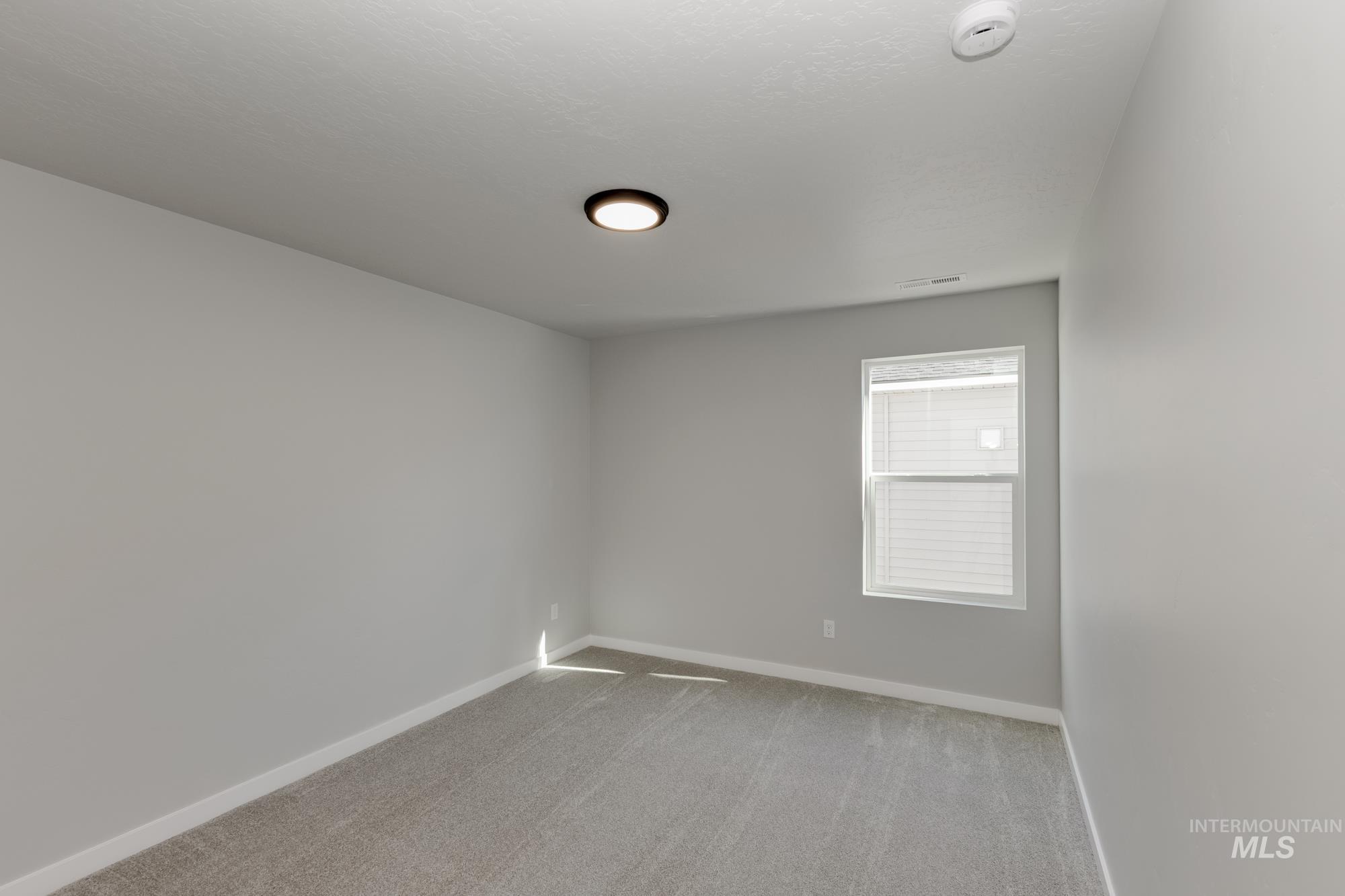Spare room with light carpet and baseboards
