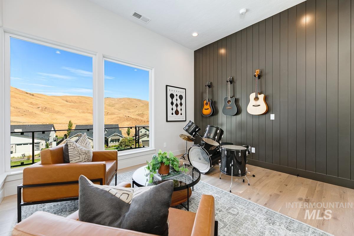 Living area with light wood finished floors, a mountain view, and wooden walls