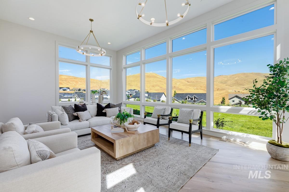 Living area featuring a chandelier, healthy amount of natural light, a mountain view, wood finished floors, and recessed lighting