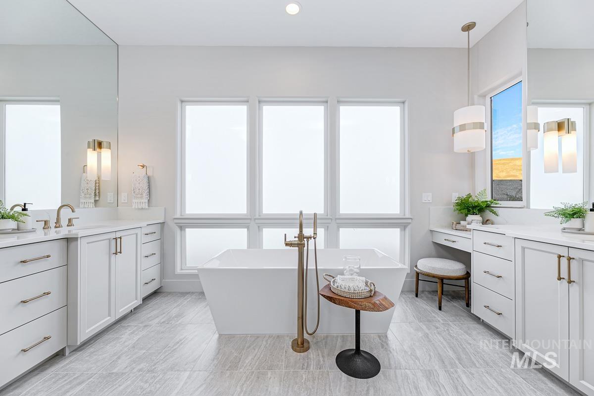 Full bath featuring two vanities and a freestanding tub