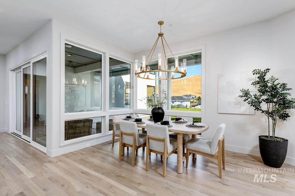 Dining room with light wood-type flooring and a chandelier