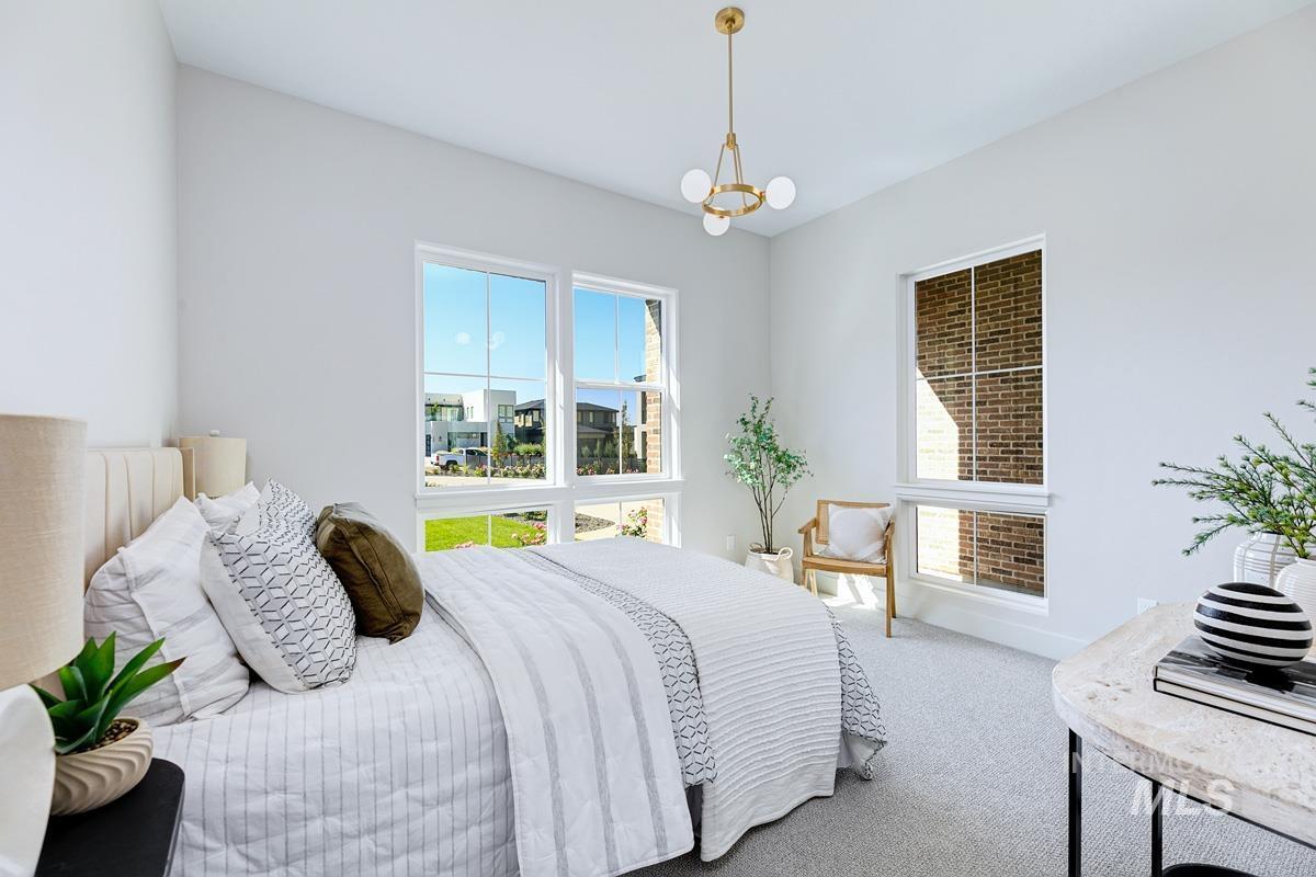 Carpeted bedroom featuring baseboards and a chandelier