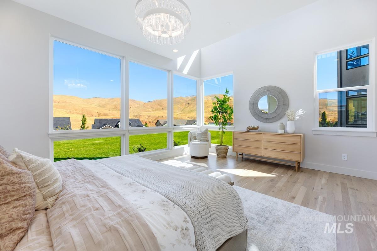 Bedroom with light wood-style floors, a mountain view, and a chandelier