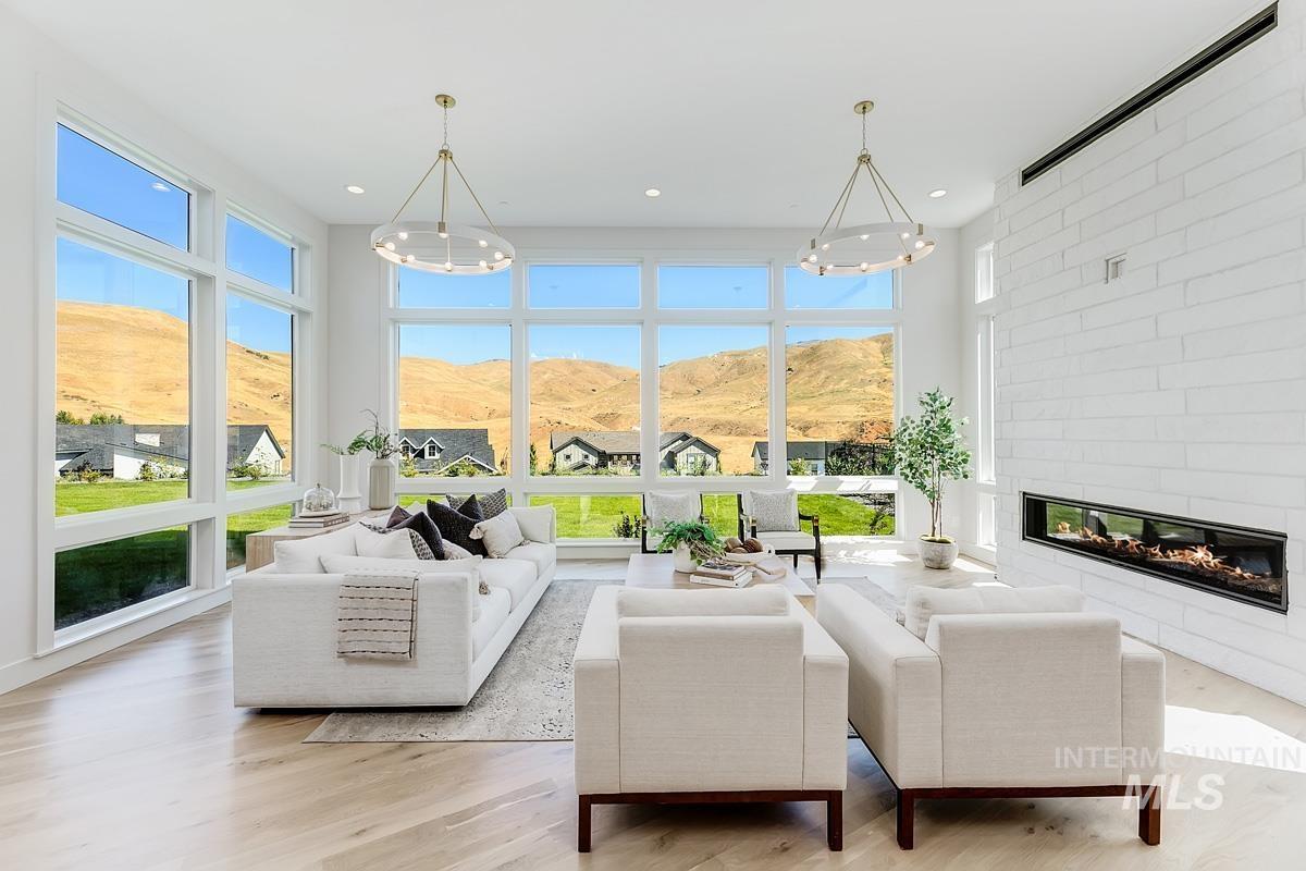 Living area with a large fireplace, a mountain view, light wood-style flooring, a chandelier, and recessed lighting