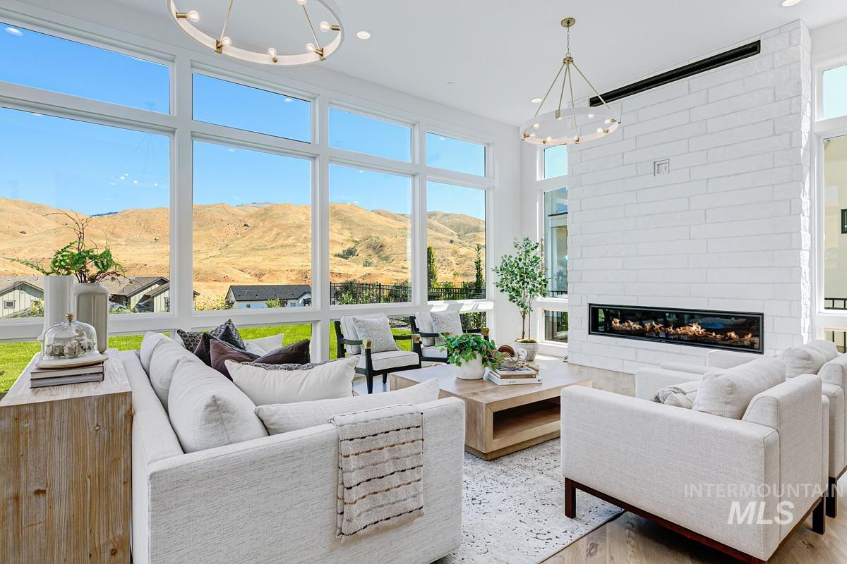 Living area with a chandelier, a mountain view, a large fireplace, and wood finished floors