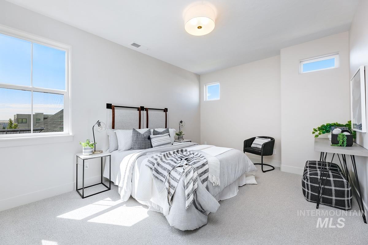 Bedroom with light colored carpet and baseboards