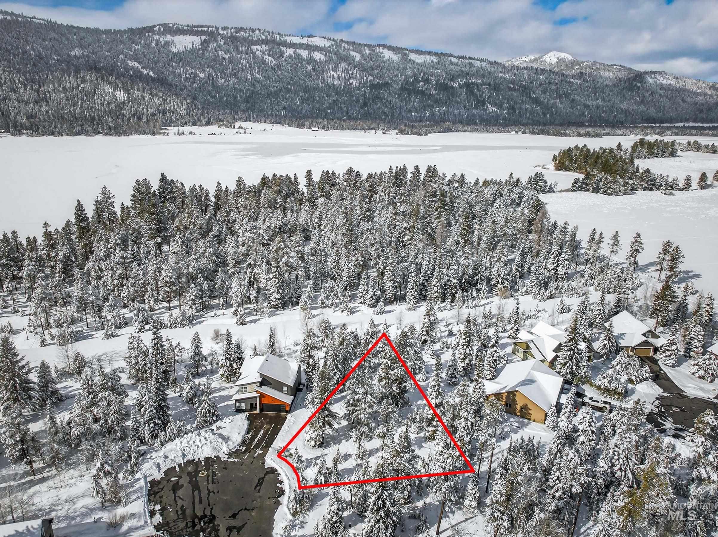 Snowy aerial view featuring property boundaries highlighted and a mountain view