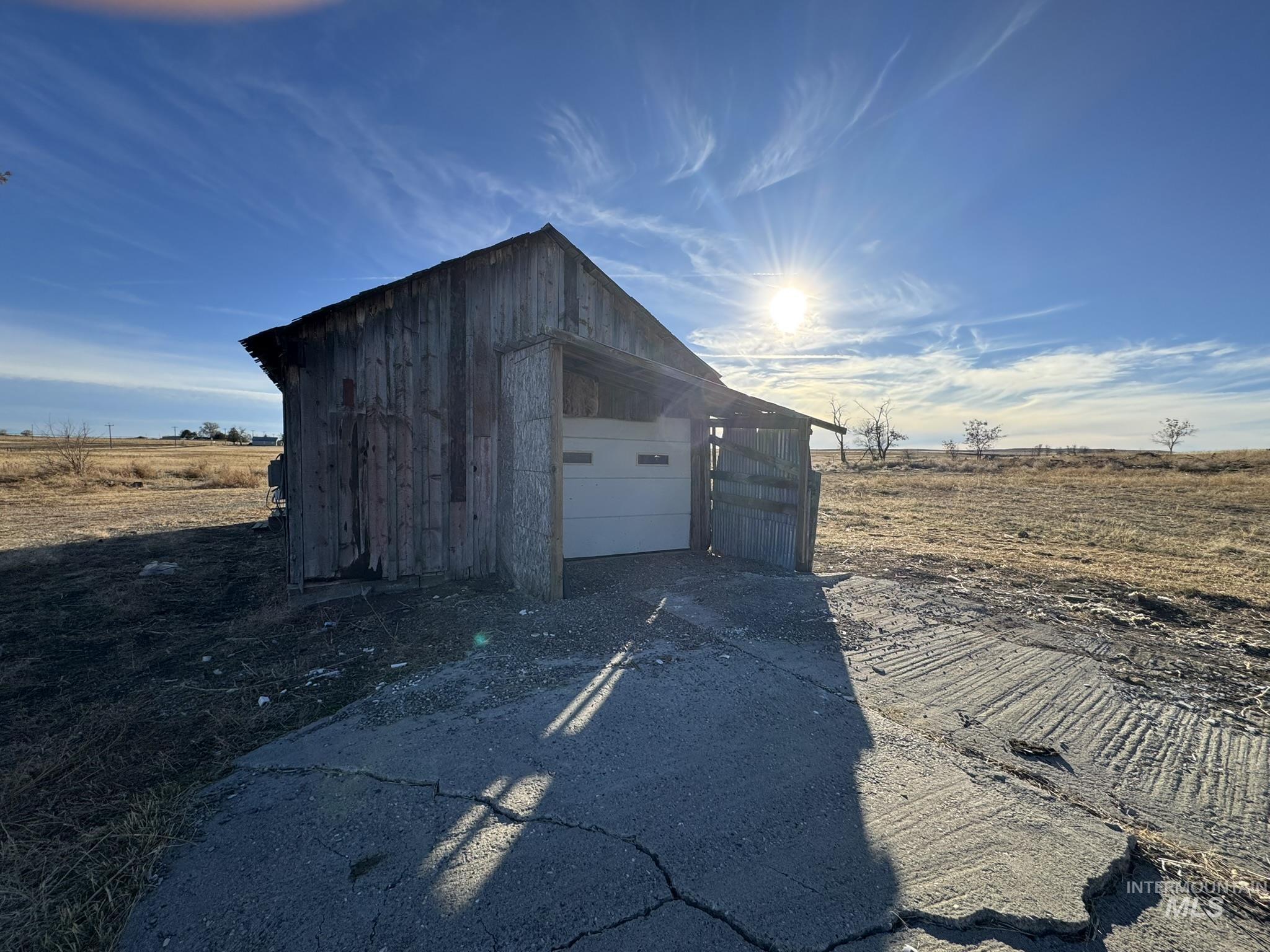 View of outdoor structure with driveway and a view of rural / pastoral area