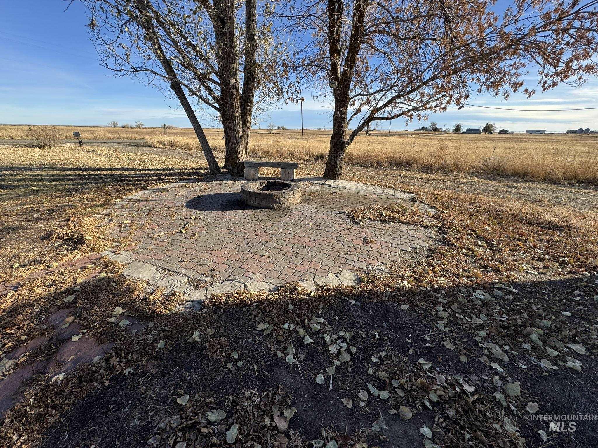 View of yard with a patio area, a view of countryside, and an outdoor fire pit