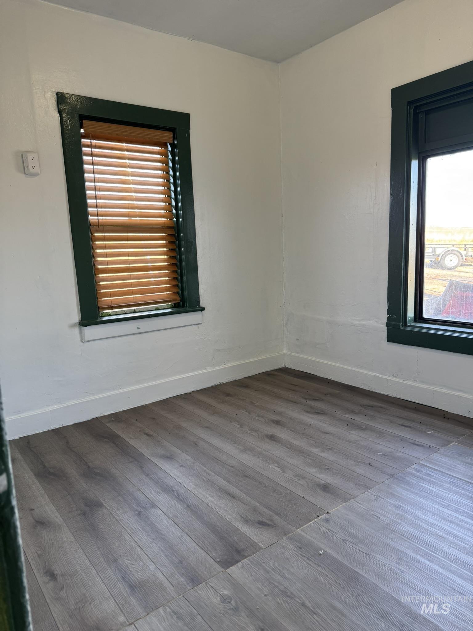 Spare room featuring dark wood-style flooring and healthy amount of natural light