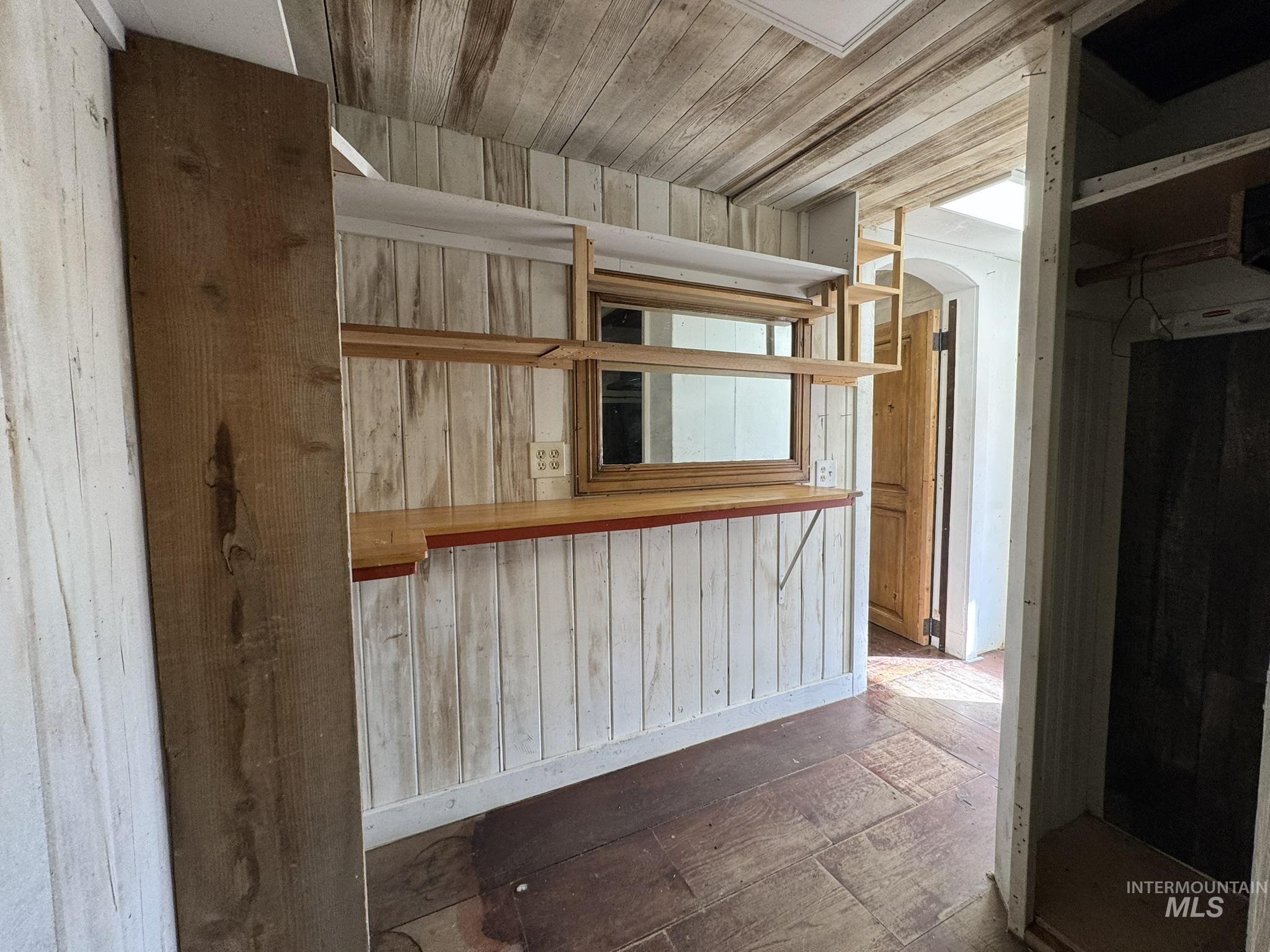 Kitchen featuring wooden walls and arched walkways