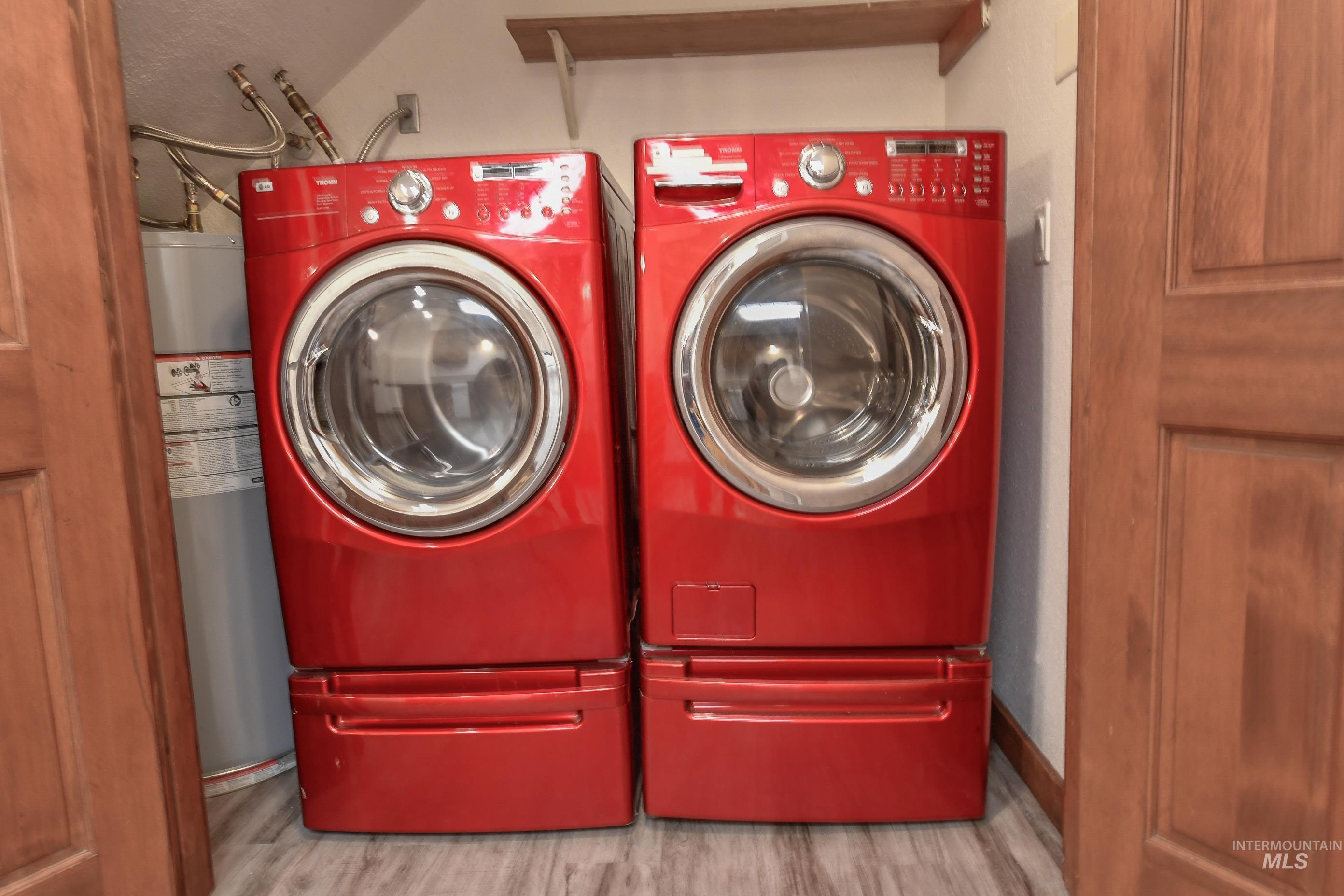Laundry area with washer and clothes dryer and wood finished floors
