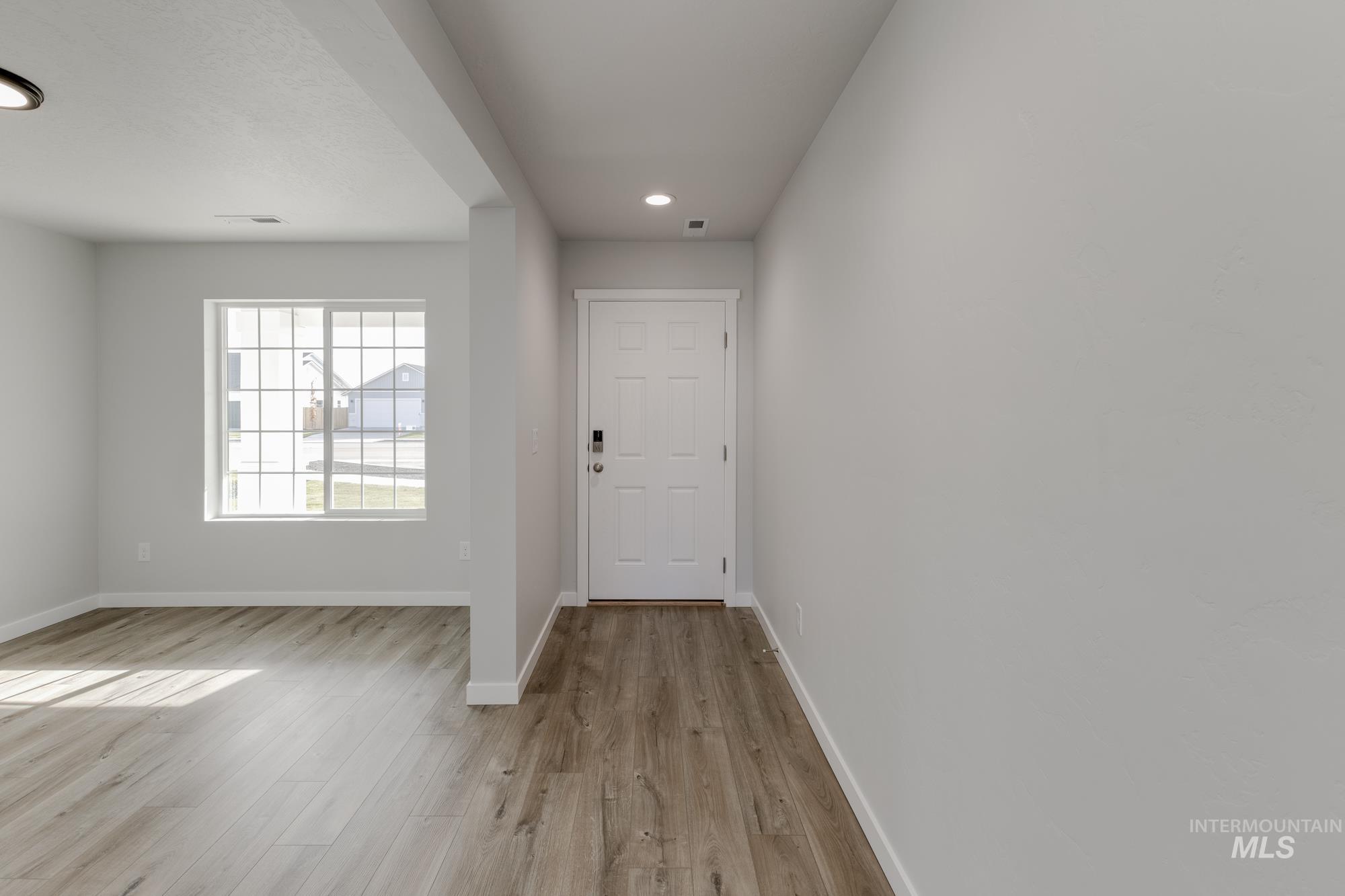 Doorway featuring wood finished floors and recessed lighting
