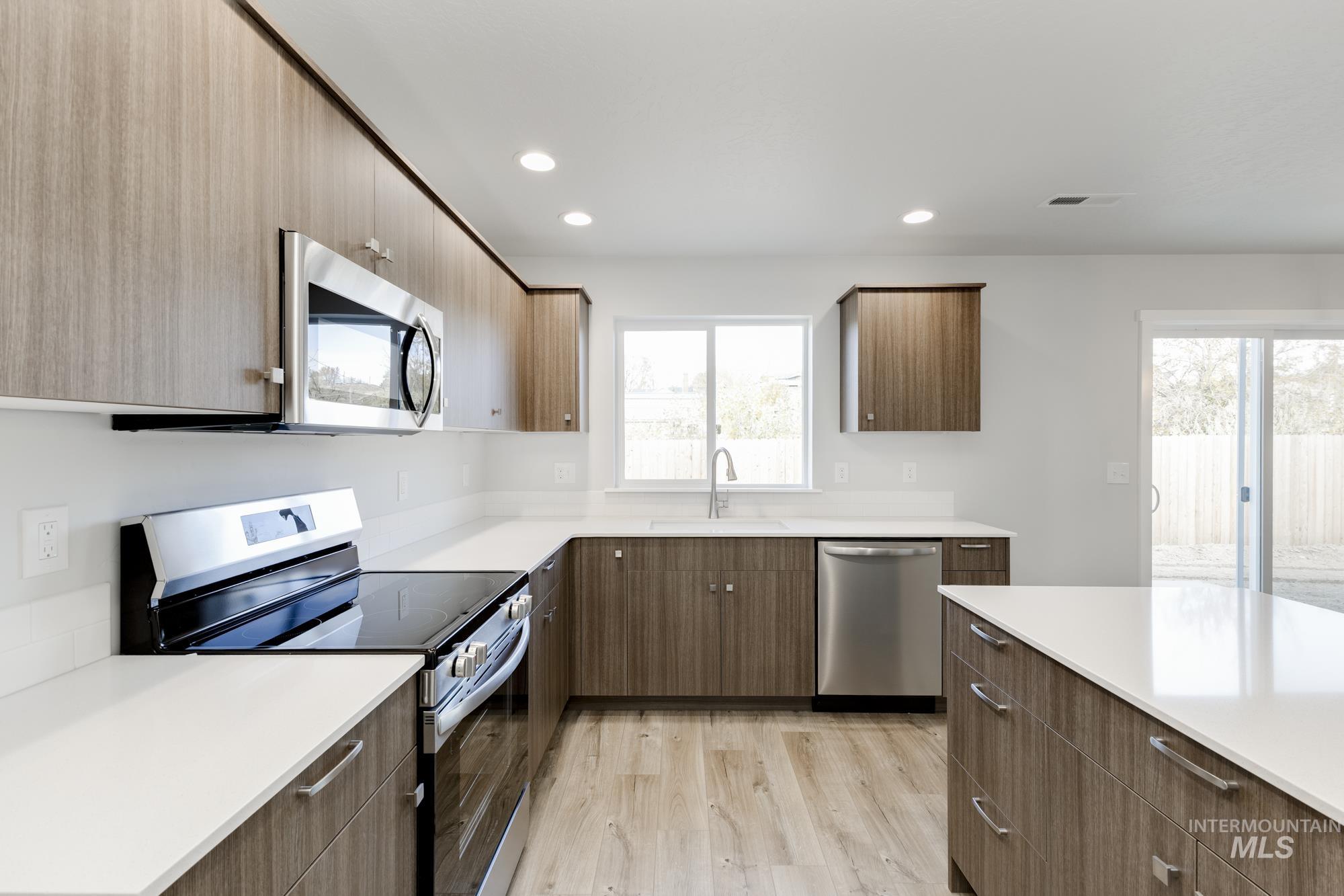 Kitchen featuring stainless steel appliances, recessed lighting, light wood-type flooring, and modern cabinets